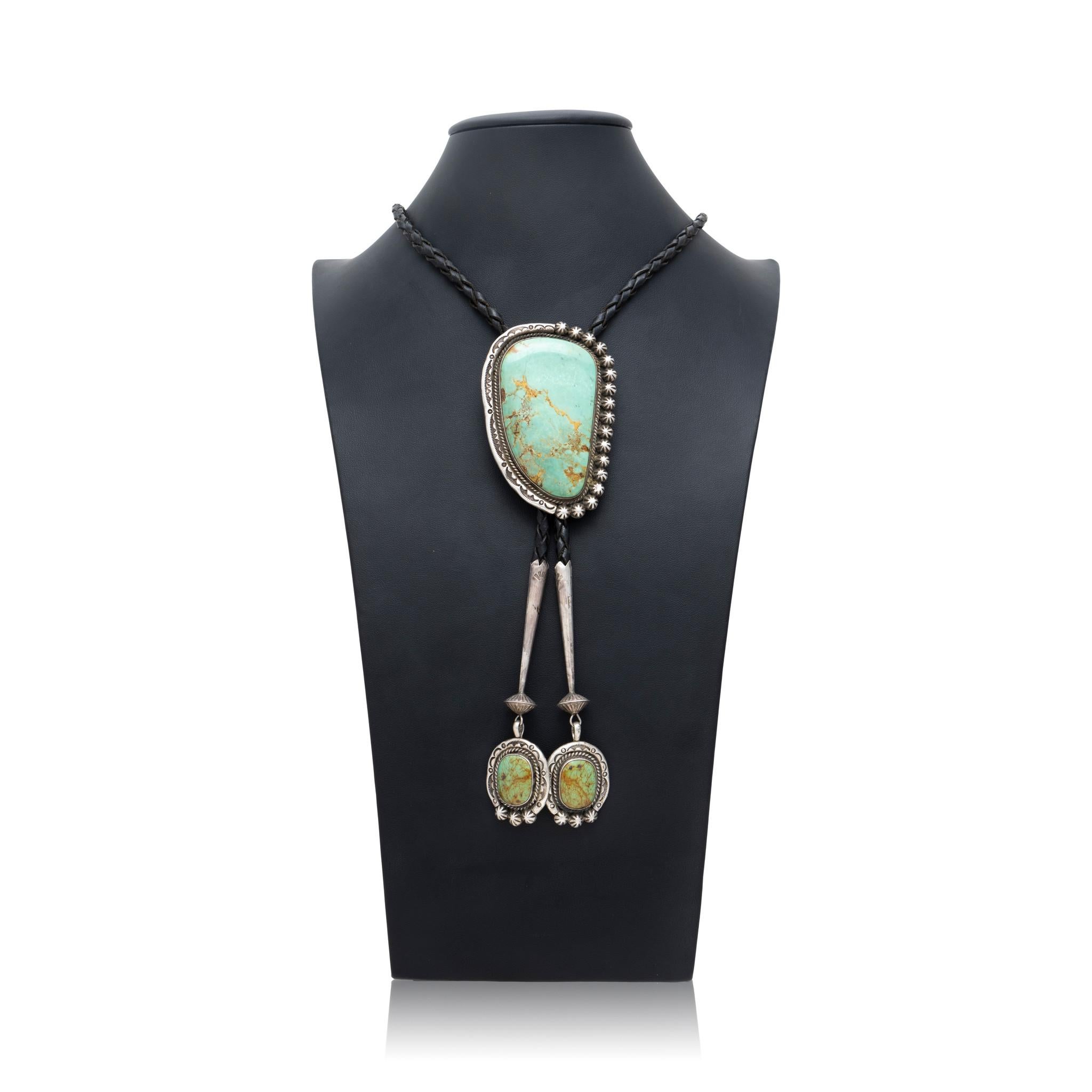 Native American Navajo Indian sterling silver and Royston turquoise bolo tie by silversmith K. Tareky. This exceptional piece features large natural, untreated center stone set in classic sterling twisted rope border with hand stamped palmettes and