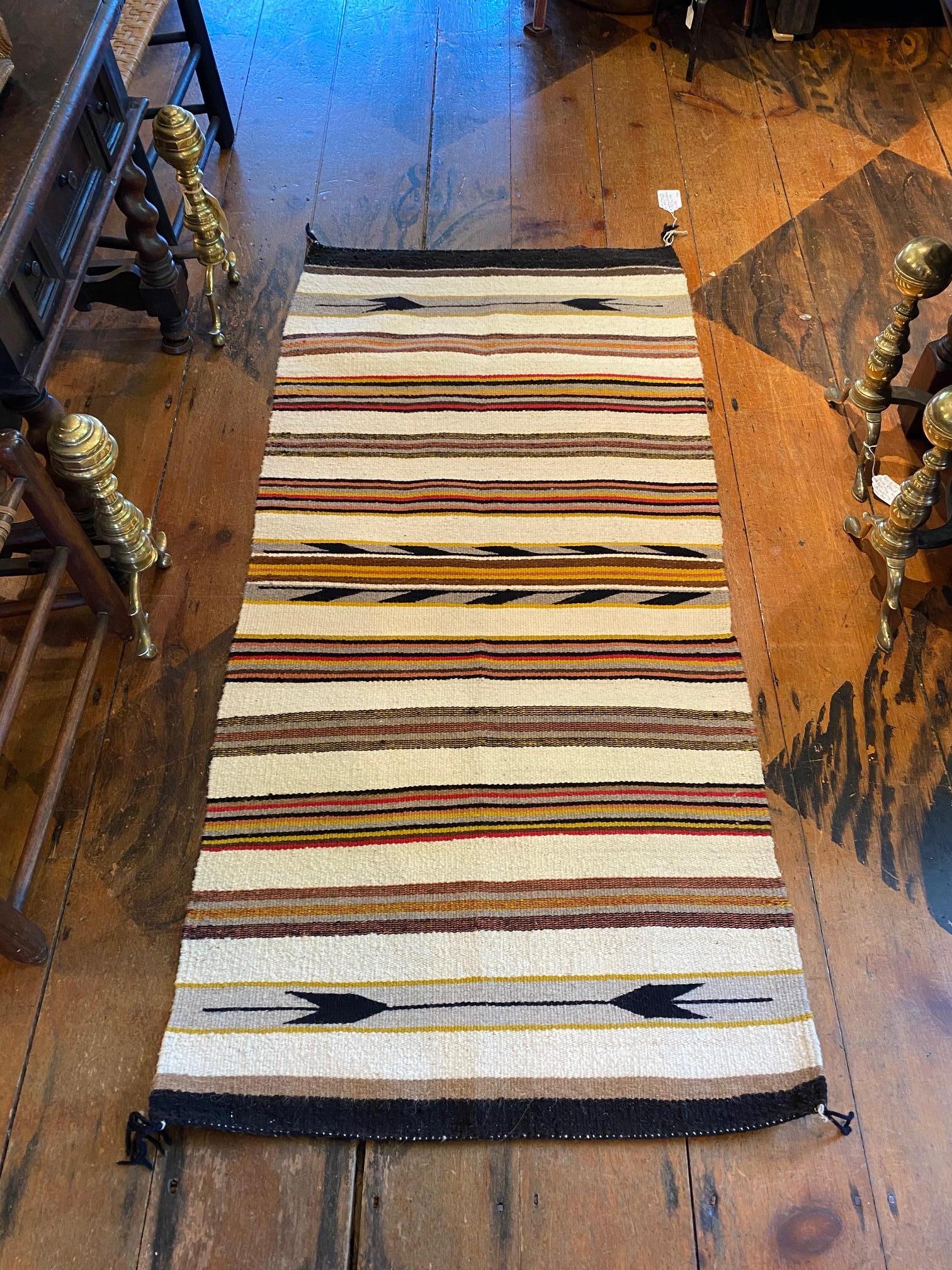 Antique Navajo rug, circa 1920s, from the estate of the late Dan Fogelberg, Mountain Bird Ranch in Colorado. The hand loomed woolen rug with arrow and stripe pattern has a lovely soft palette and is in excellent condition.

Measures: 64 in L x
