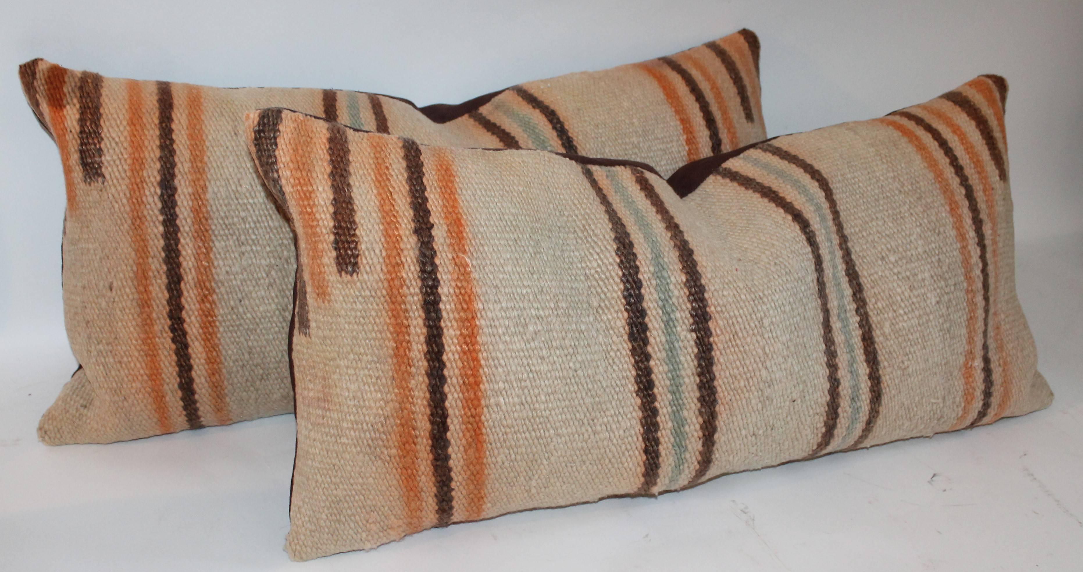 This pair of very early saddle blanket weaving pillows are in good condition with slight fade in a consistent way. The backing are in a brown cotton linen.