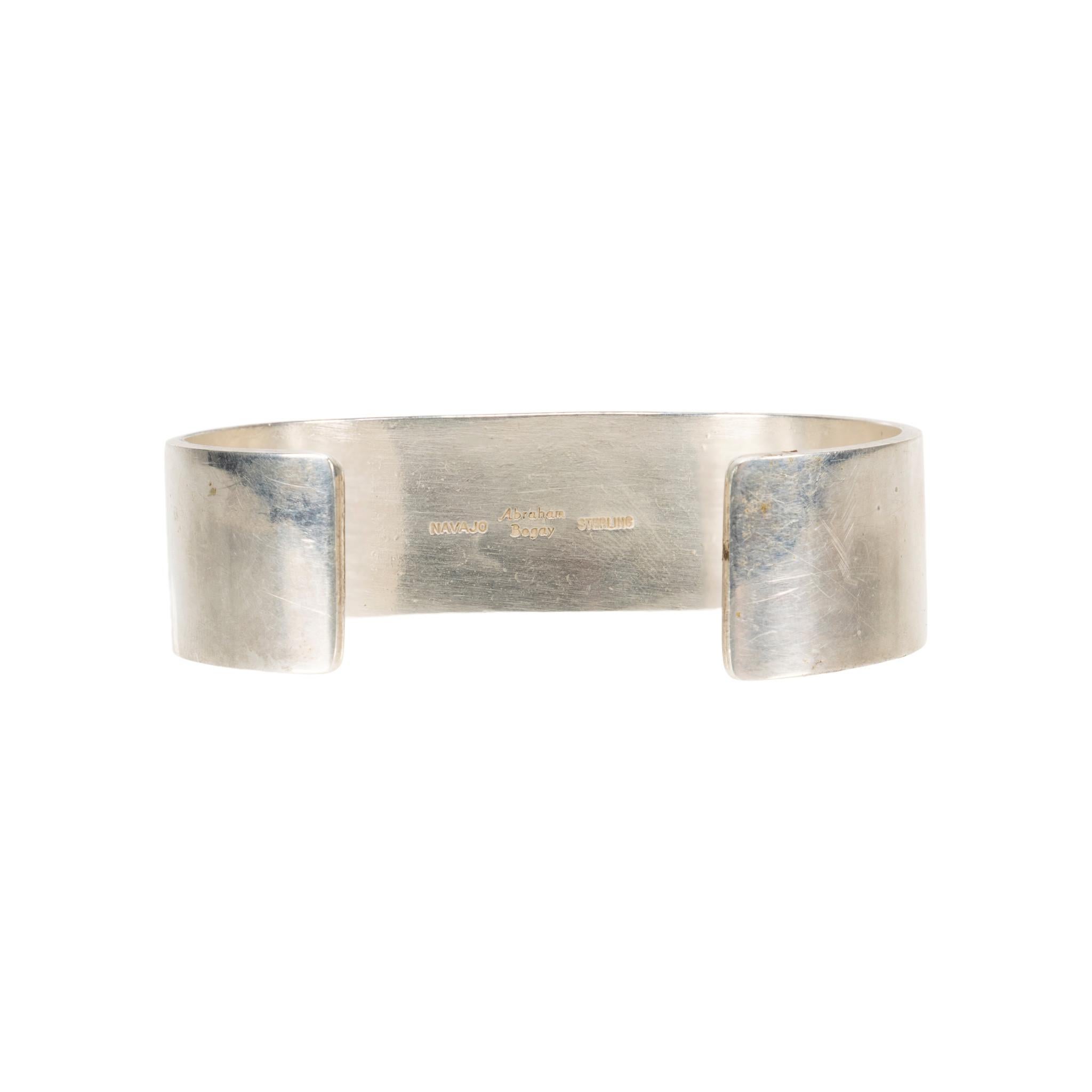Bracciale Navajo in corallo e sterlina dell'argentiere Navajo Abraham Begay. Cabochon di corallo rosso sangue in rilievo circondato da disegni geometrici impressi. Timbro 