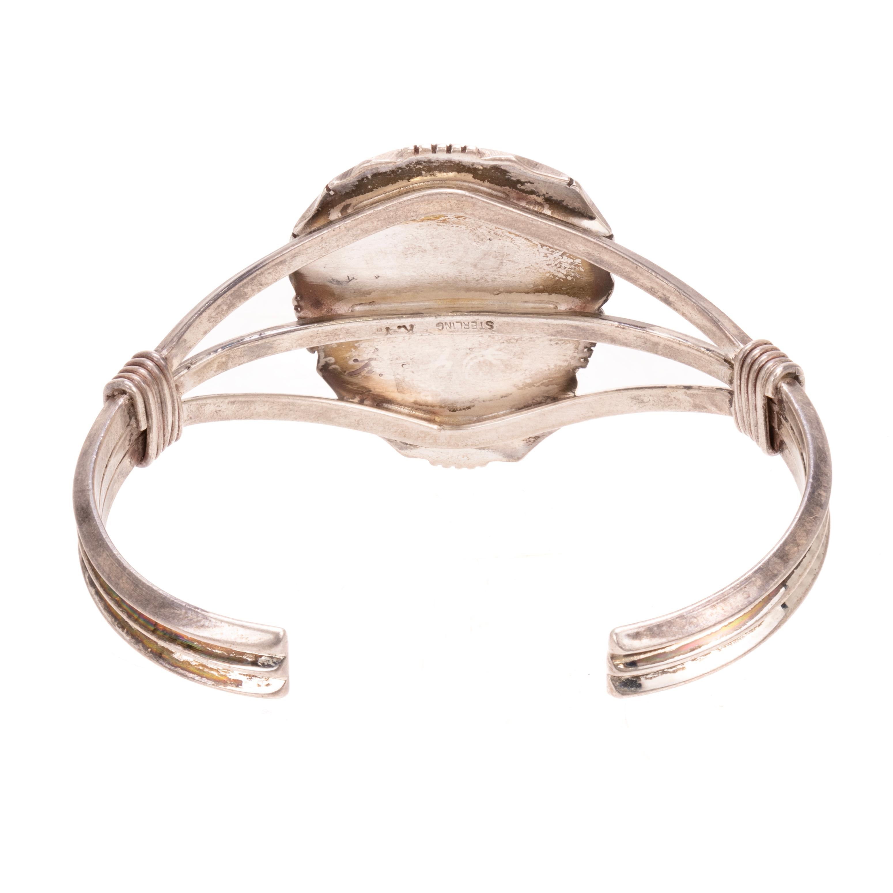 Bracciale Navajo in turchese a pietra singola e argento sterling. Con pietra centrale dal taglio asimmetrico, di colore blu brillante e matrice d'argento. In una montatura a castone con corda ritorta e bordo tratteggiato. Attaccato a un insolito