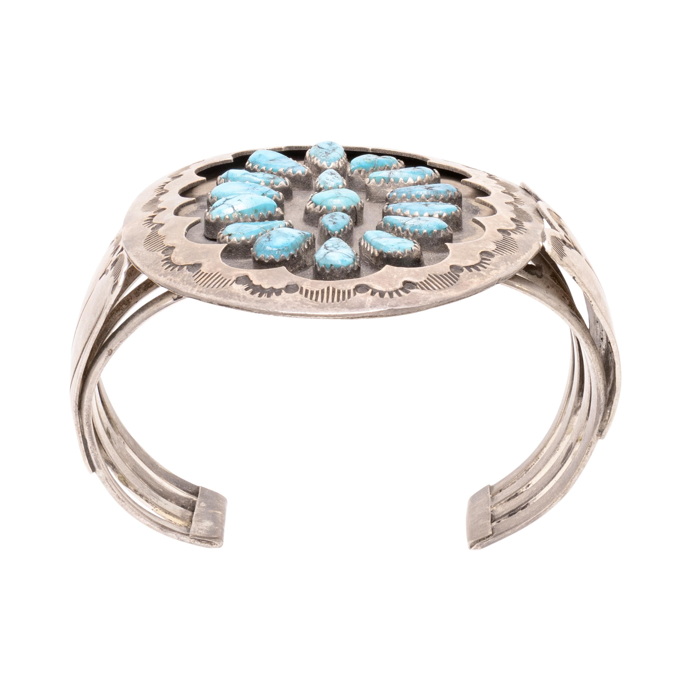Navajo teardrop cluster cuff bracelet. 17 Kingman stones arranged in substantial shadowboxed sterling with stamped border and fan sides. Stones are a deep blue with black matrix. Old Pawn. Acquired from an individual who purchased directly on the