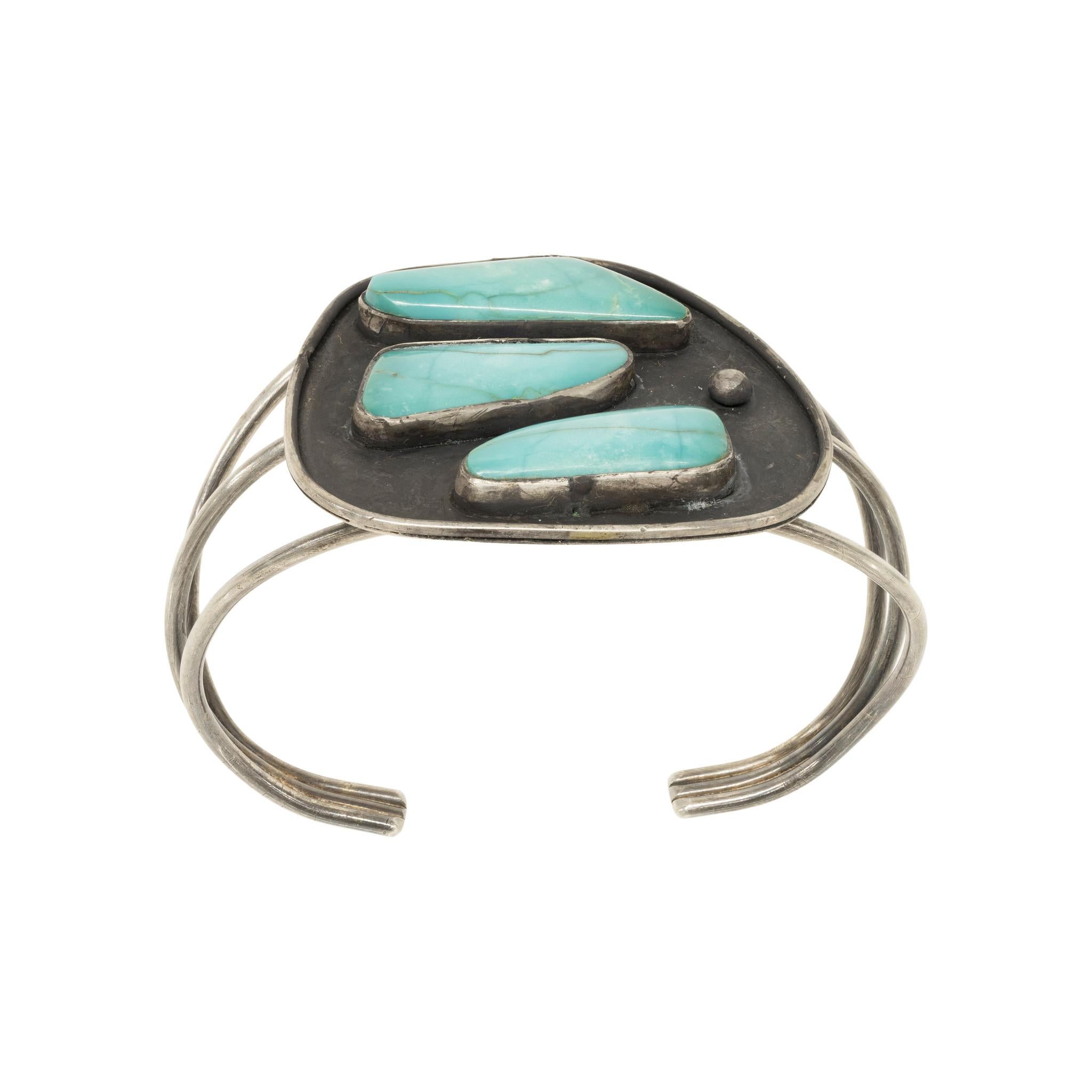 Navajo sterling silver and Kingman turquoise cuff bracelet. Three natural, untreated stones in bezel setting on antique shadowbox with single sterling bead decoration. Stones are a lovely teal blue with cloudy white matrix and subtle lines of brown