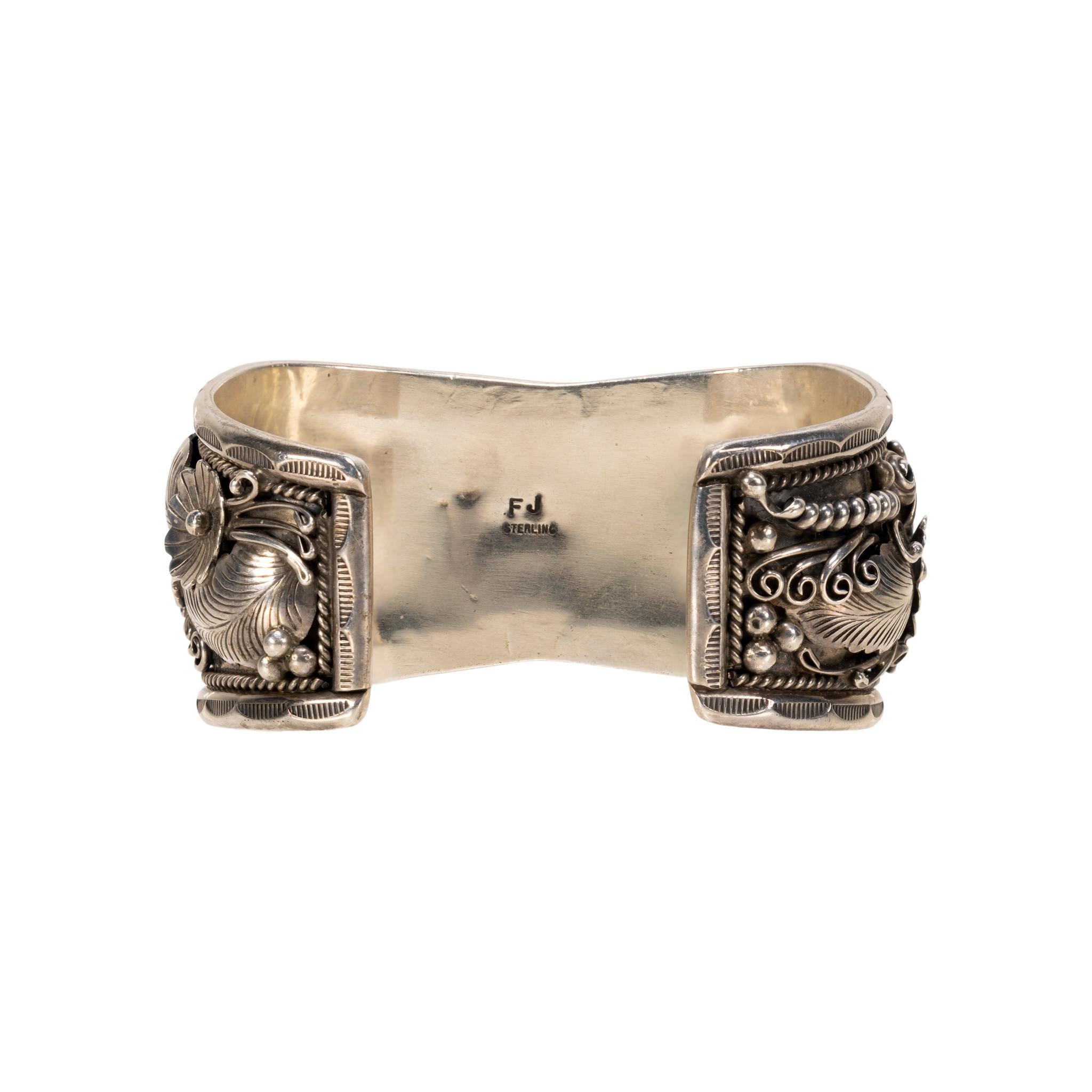 Navajo sterling silver cuff bracelet with Kingman turquoise and coral by an award-winning Navajo silversmith Francis Jones (1944 - ). Four stones surrounded by traditional leaf, floral, bead and hand stamped palmette design. Stamped 