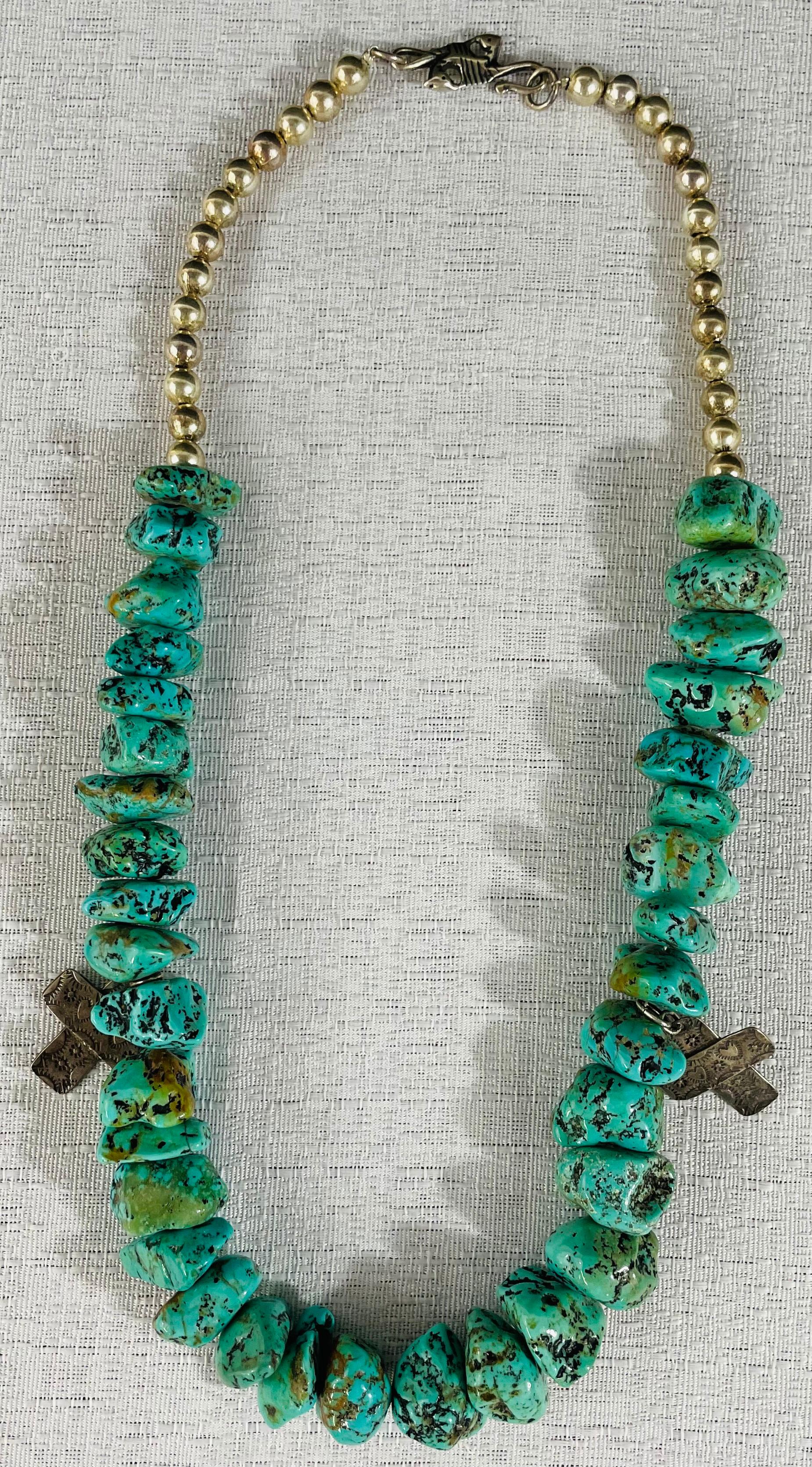A vintage Native American Navajo turquoise stone necklace with authentic 26 pearls and two carved cross pendants in sterling silver. The necklace is attributed to the Jewelry designer T-Foree. 
This vintage necklace will make a statement and is a