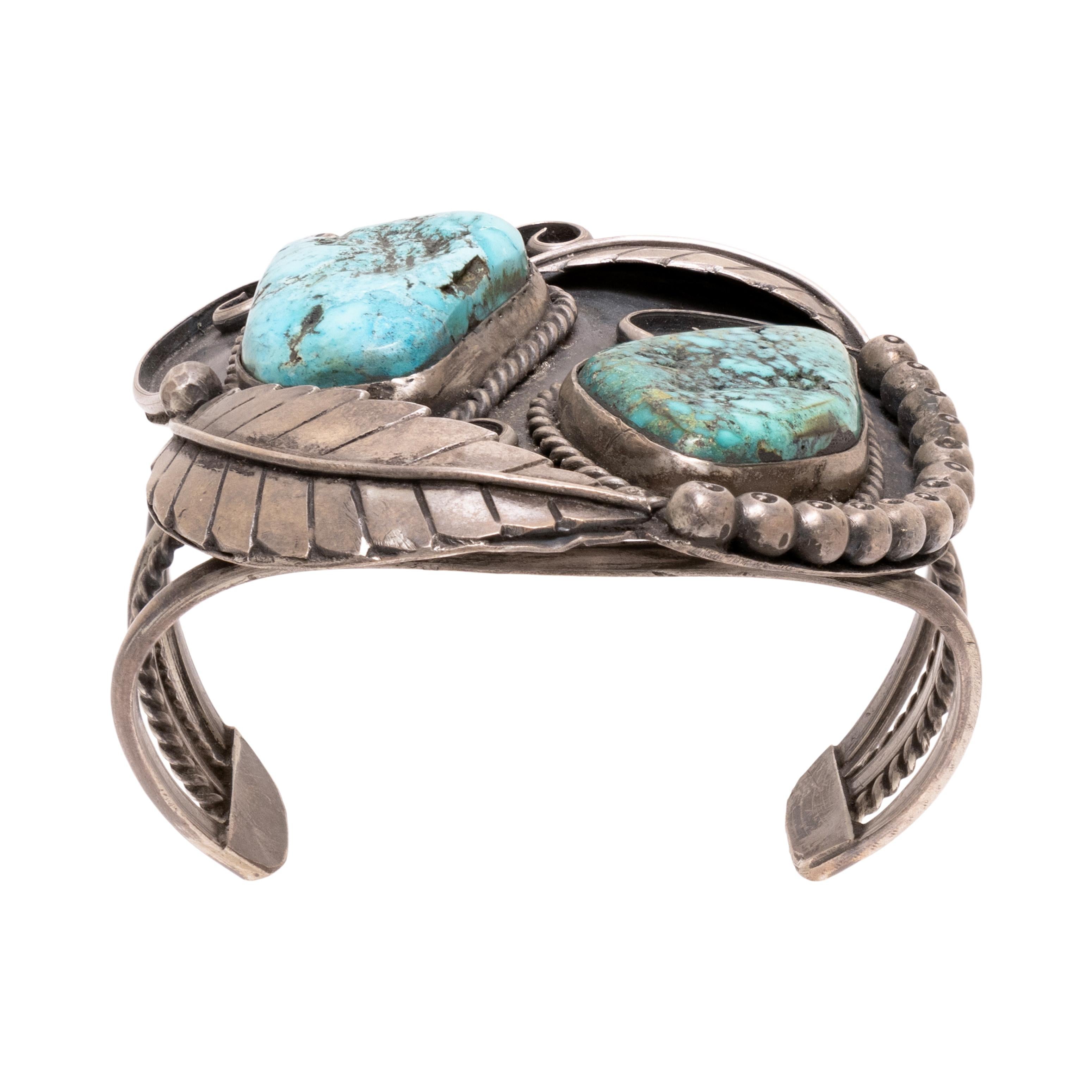 Navajo zwei Stein Türkis Armband mit Silber Blatt Design. Beide Steine sind von einer gedrehten Seilumrandung umgeben. Shadowbox hat Sterling-Perlen und verschnörkelte Details. Die Türkissteine sind leuchtend blau mit brauner, goldener und weißer