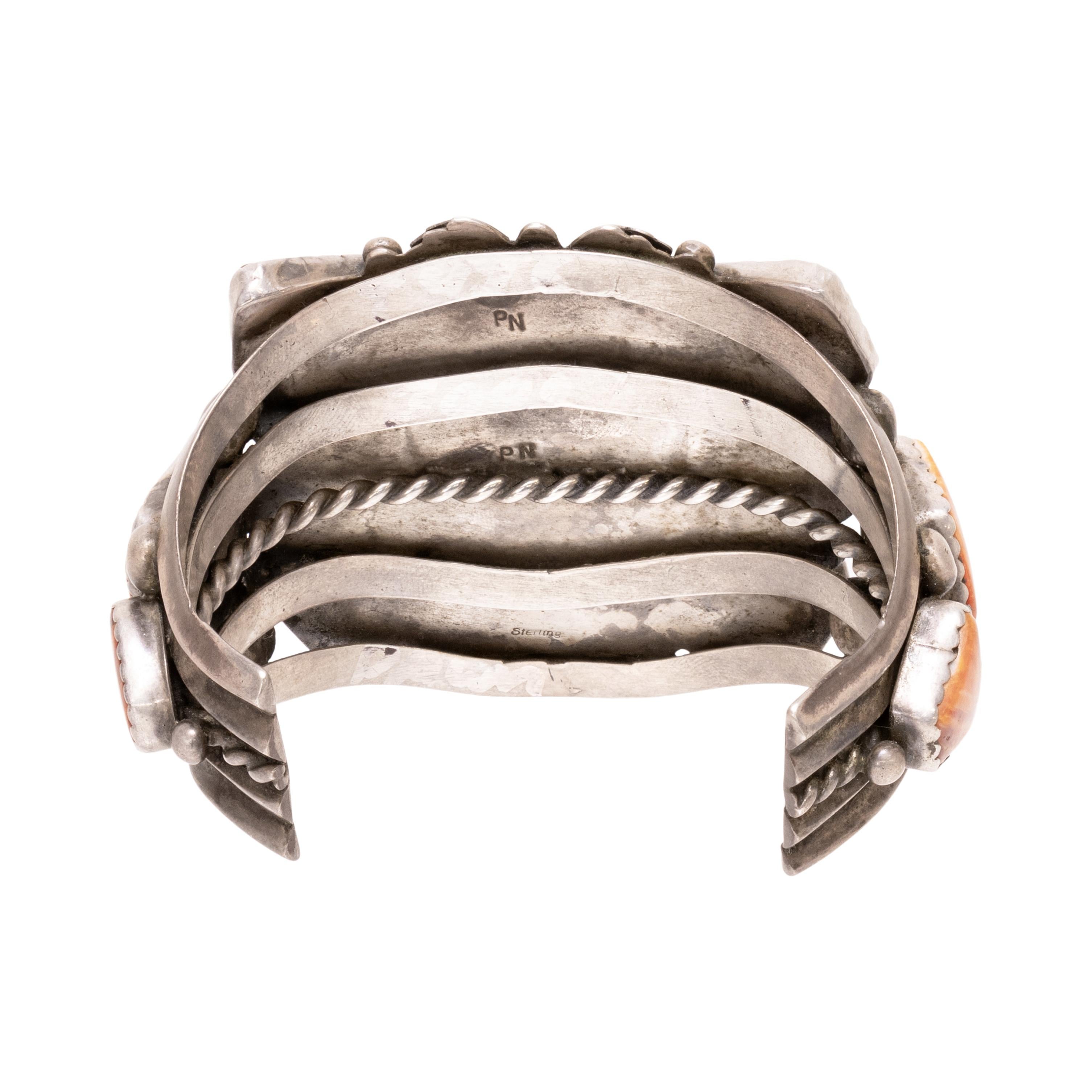 Bracciale pesante in turchese Navajo e ostriche spinose. Grande pietra centrale di turchese Carlin, con colorazione verde chiaro e matrice marrone. Circondato da dieci conchiglie di ostriche spinose a taglio geometrico, arricchito da perline in
