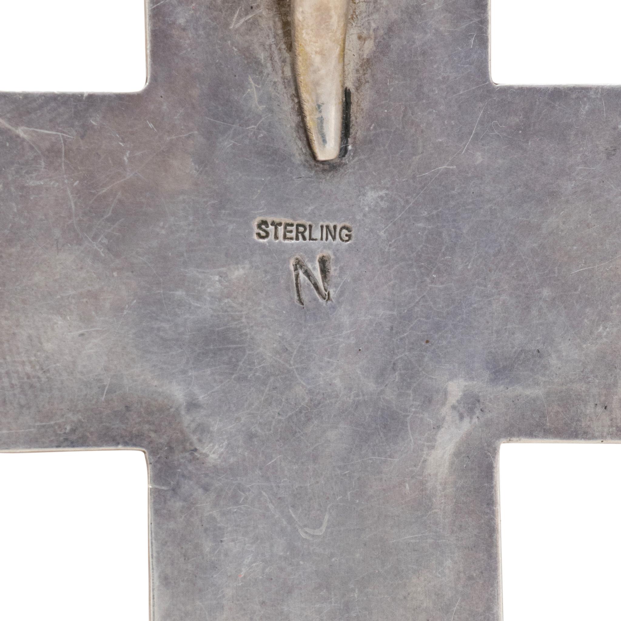 Colgante Navajo de plata de ley y cruz de turquesa de la Bella Durmiente. Veinticuatro piedras naturales cuadradas, sin tratar, engastadas en plata de ley con el clásico diseño de marca de corte. Las piedras son de un azul brillante sin matriz.