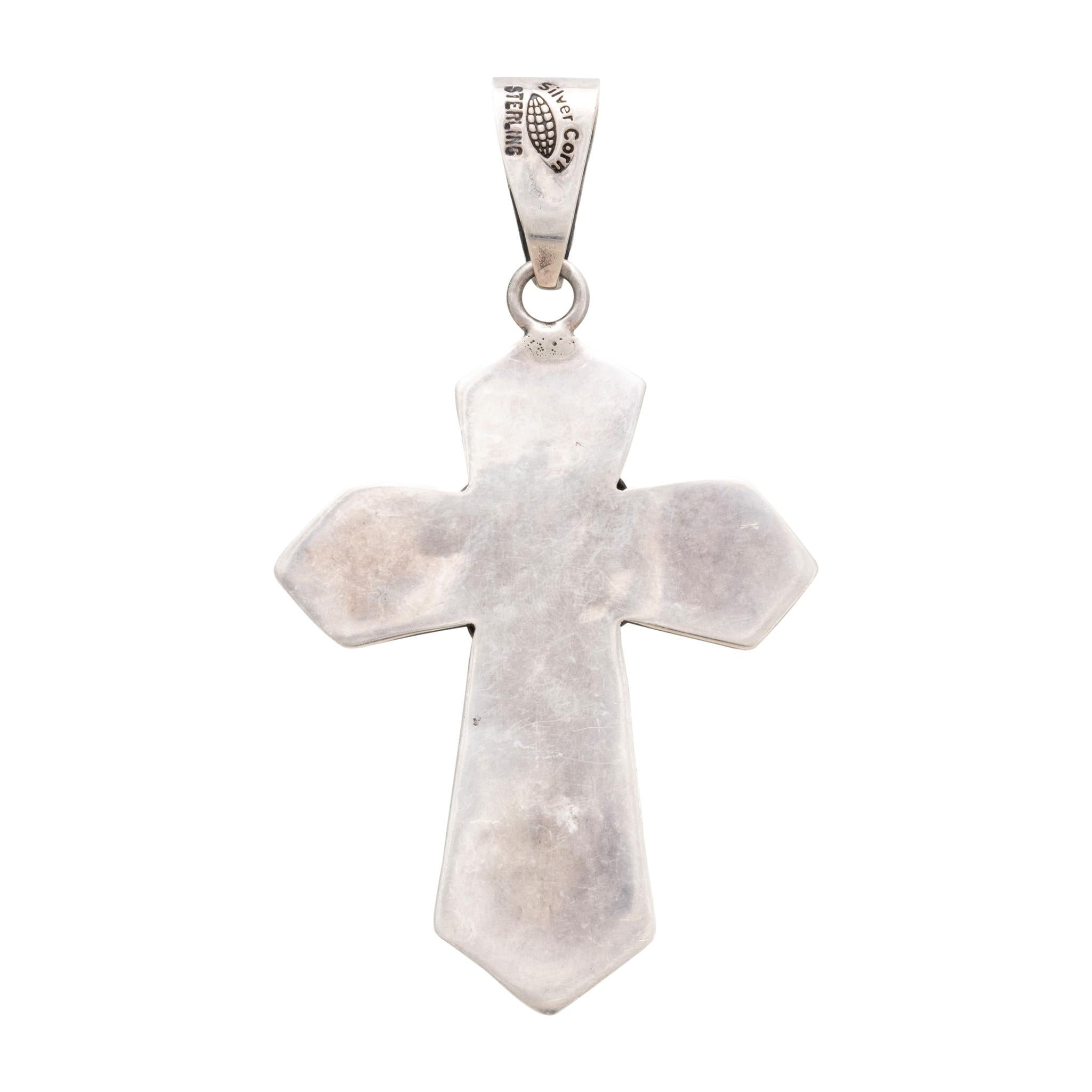 Pendentif en forme de croix en argent sterling et turquoise de Navajo. Croix en argent massif estampillé avec bordure en corde et pierre centrale en turquoise Damele. La pierre est d'une couleur vert clair avec un peu d'or et une matrice brune. En