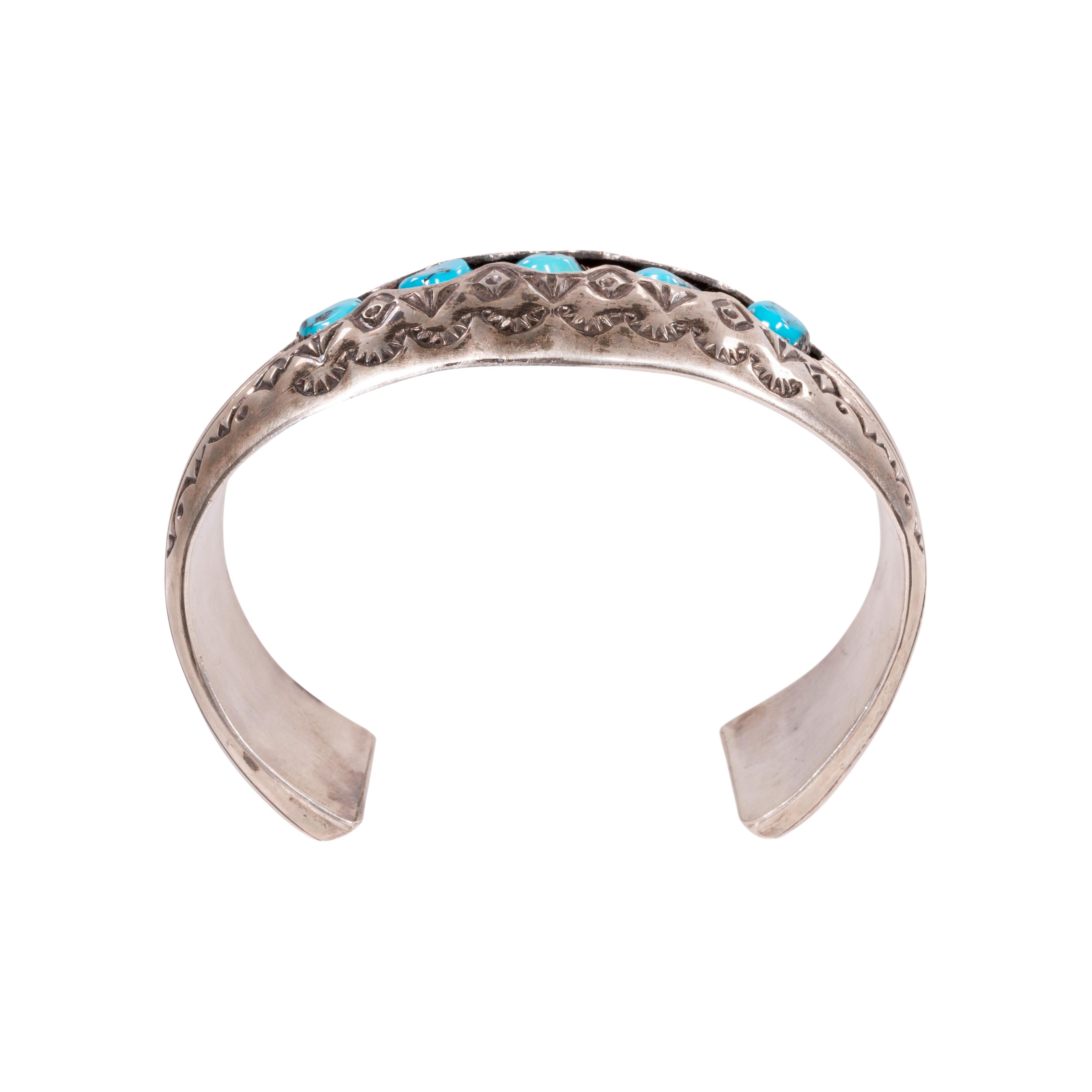 Navajo-Türkis und Sterlingsilber Manschettenarmband. Fünf schöne Morenci-Steine im Rundschliff mit leuchtend blauer Farbe und dunkler Matrix. In ausgeschnittener Schattenboxfassung in dicker Manschette mit handgeprägten Details. Rückseitig