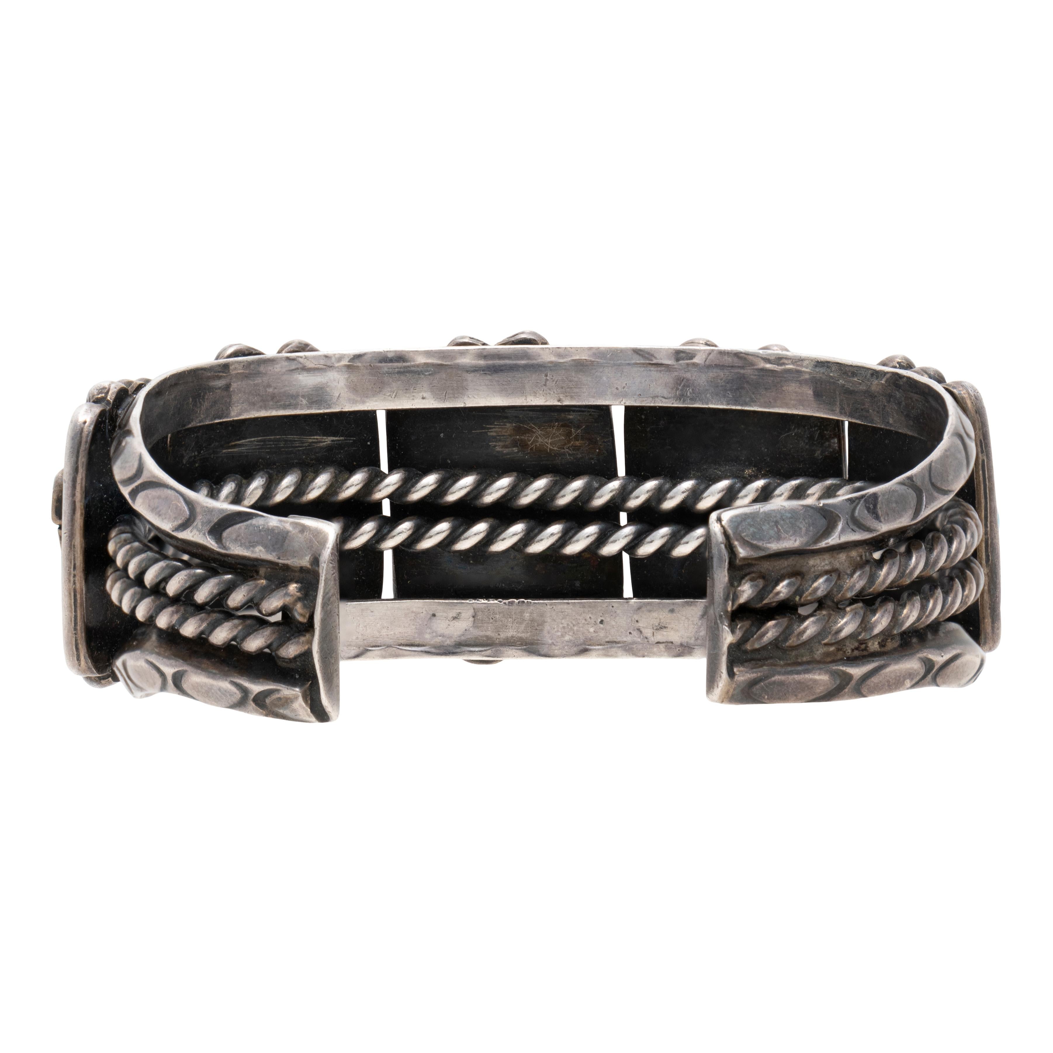 Navajo Kingman Türkis und Sterlingsilber Manschettenarmband. Fünf natürliche, unbehandelte Steine in Schattenboxen mit gedrehter Seileinfassung auf handgeprägtem Band mit Schnecken- und Seildetails. Stabil und solide mit schöner Patina. Die Steine