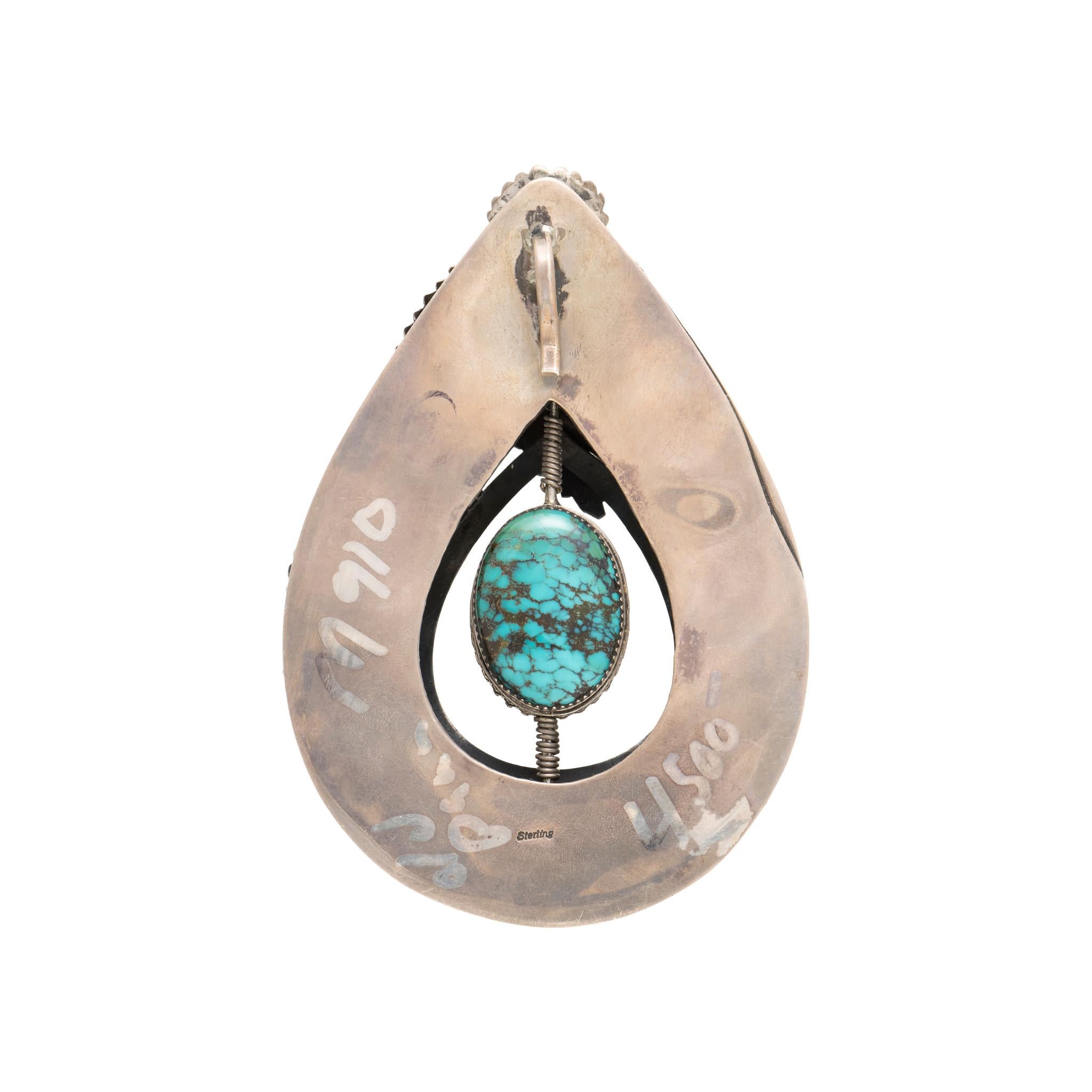 Large Native American Navajo Indian highly detailed sterling silver pendant with rotating Kingman turquoise center stone. Stone is floating in pendant with ornate and intricate sterling details of leaves, hand stamped palmettes, flowers and twisted