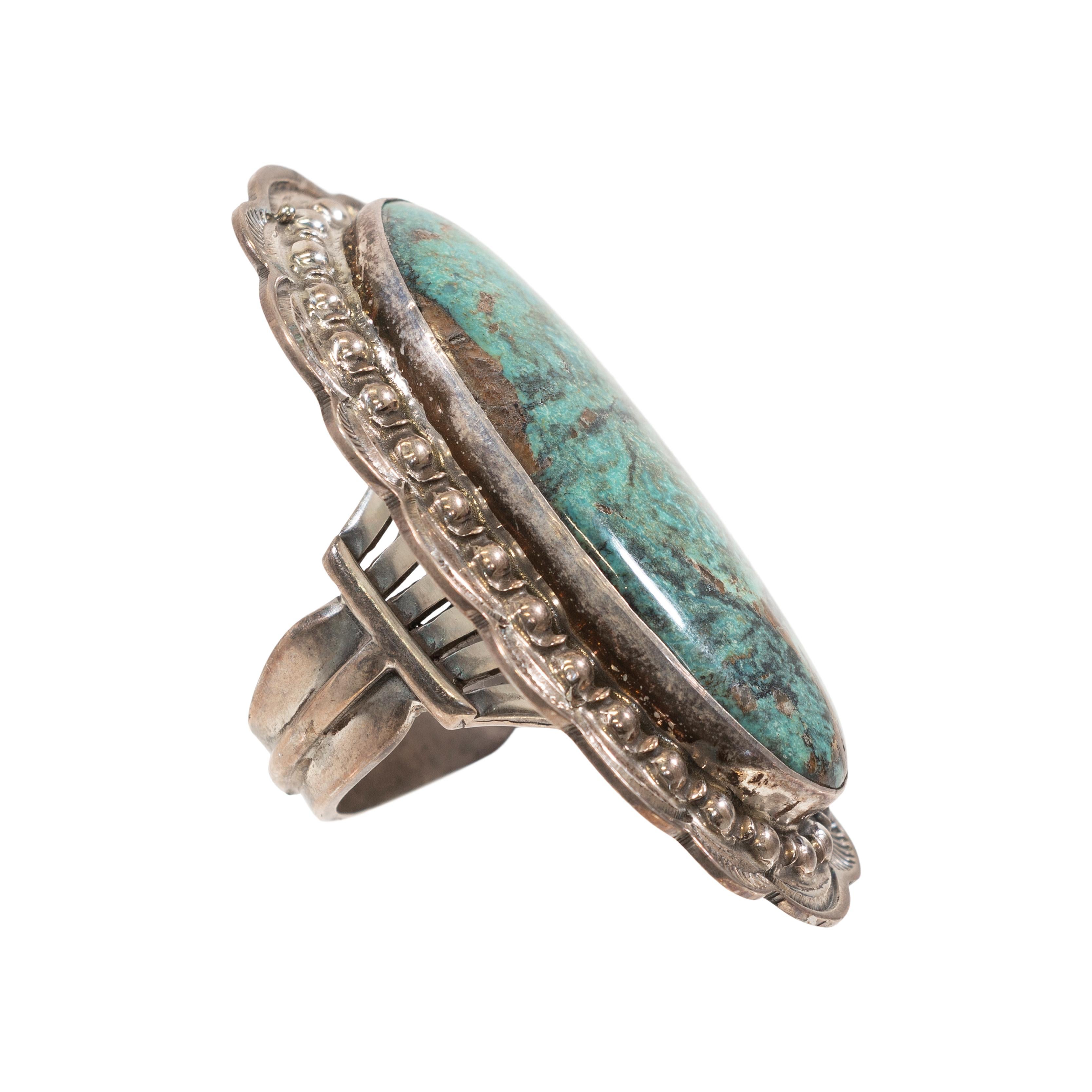 Large Navajo turquoise ring, marked 'Charles Johnson'. Sterling. Beautiful hand stamped silver work of Navajo pearls and lines. 

PERIOD: After 1950

ORIGIN: Navajo, Southwest

SIZE: Ring Sz: 8.5 ; Face: 2 1/4