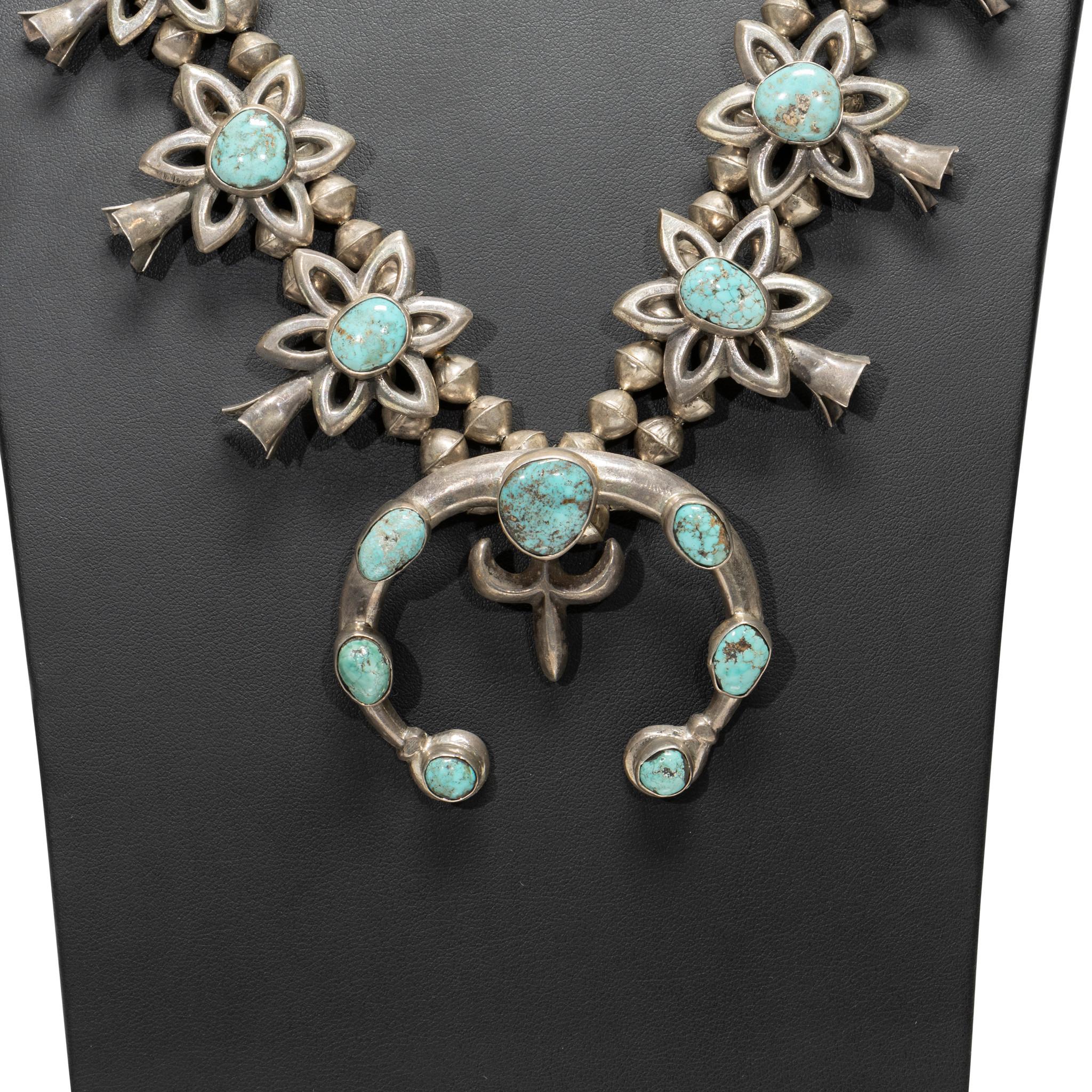 Navajo sand cast turquoise and sterling squash blossom necklace. 10 quality Kingman turquoise stones on each side in flower design with 7 additional matching stones on naja. Stones are a light blue with brown and gold matrix, with both stones and