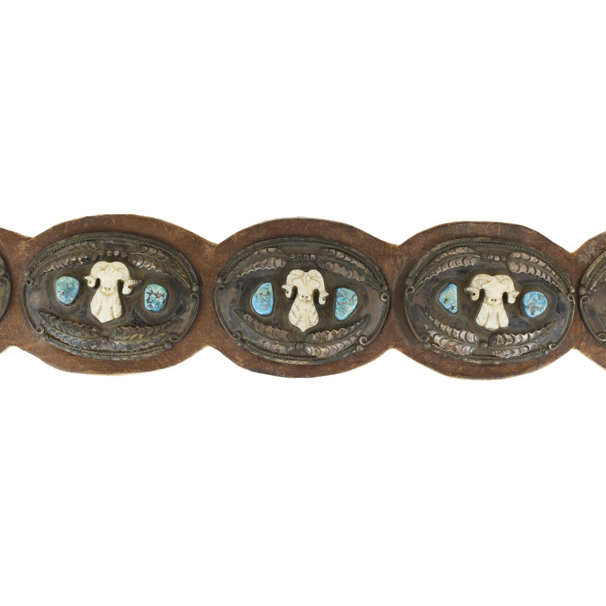 Carved ivory bighorns with Blue Kingman Mine turquoise. Wonderful patina. Original leather; nine conchos total. Signed A.J.M.

PERIOD: After 1950
ORIGIN: Navajo, Southwest
SIZE: Total belt length 56