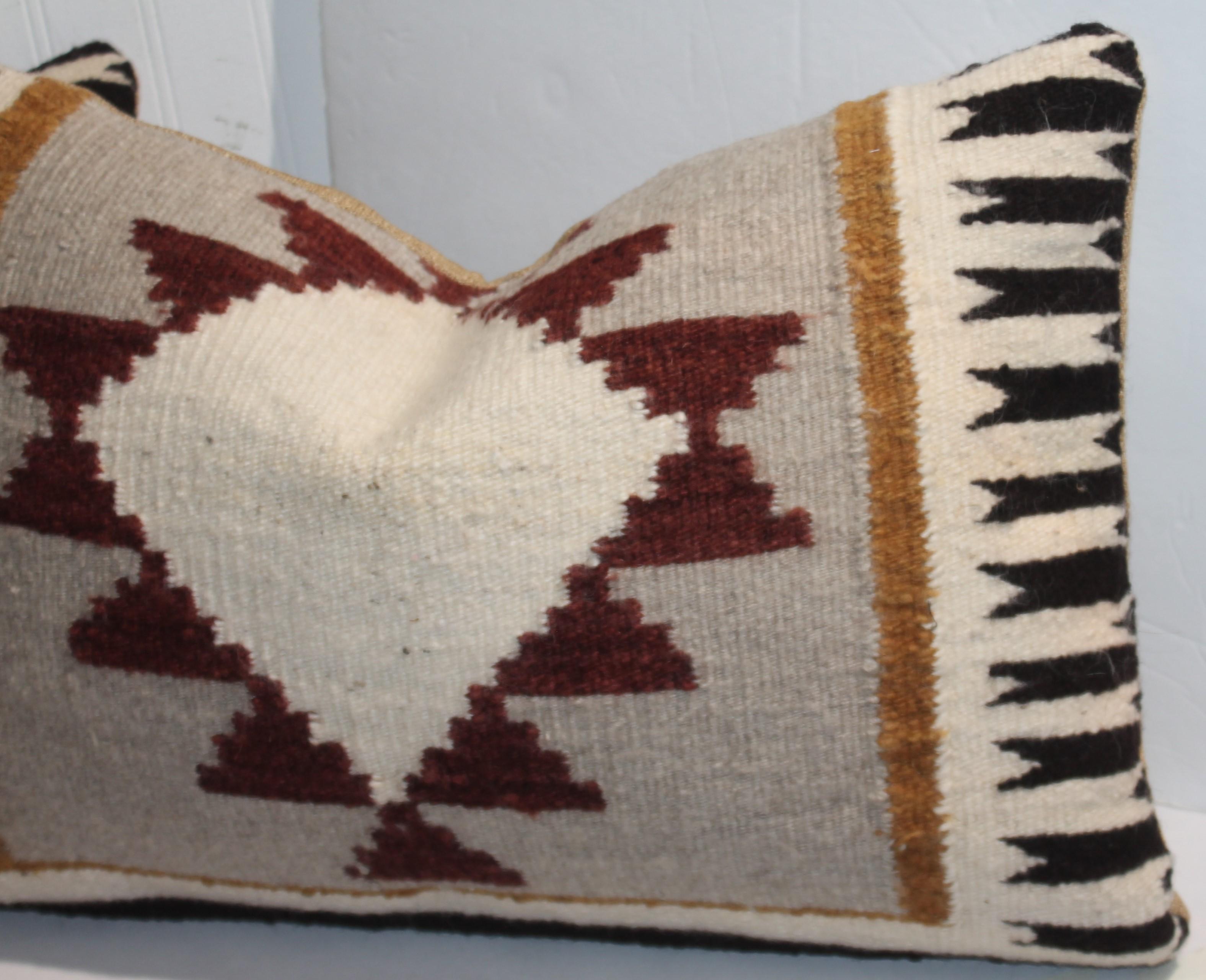 Navajo Indian eye dazzler woven bolster pillows with a great side border design. wonderful colors to the design provide a pleasing aesthetic. Vintage linens backing with custom made down and feather inserts.