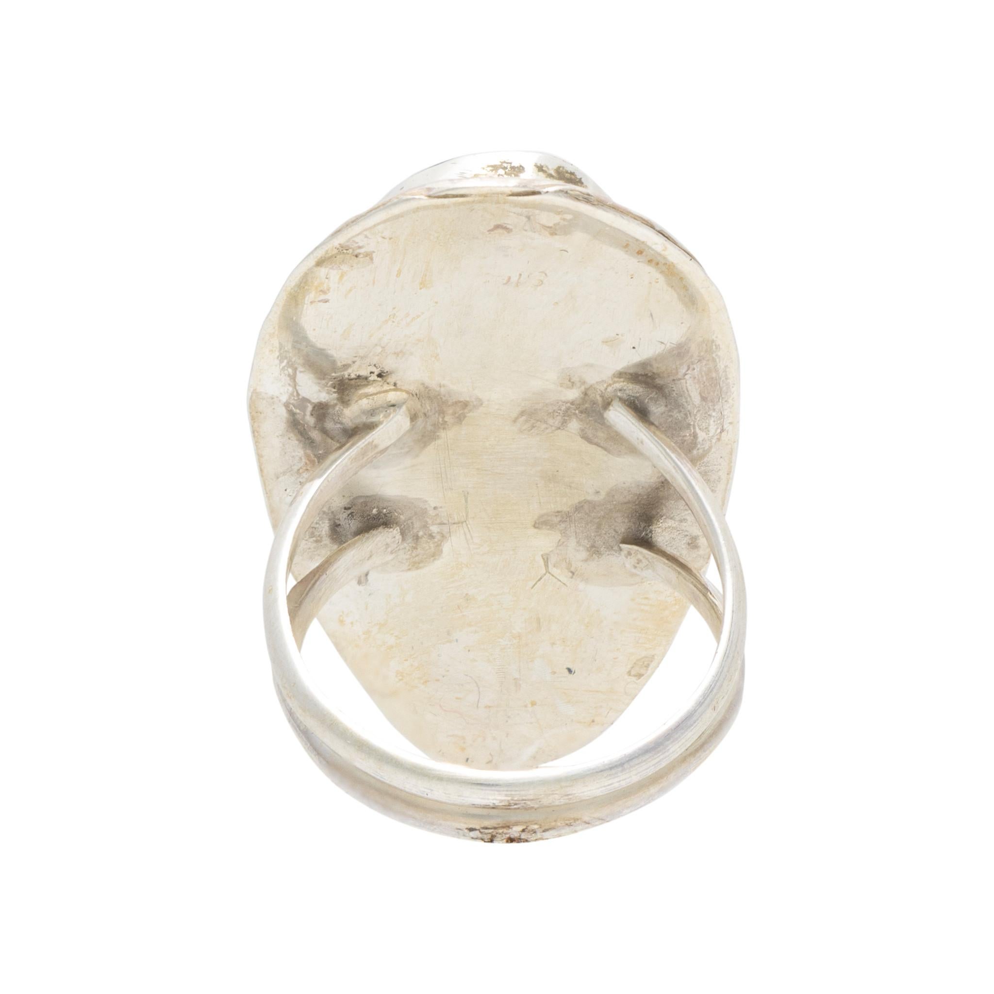 Native American Navajo Indian white buffalo turquoise ring set in sterling silver. Large center stone surrounded by classic twisted rope border having hand stamped palmettes. Stone has stark black and white colors with variated matrix.  Stone is cut