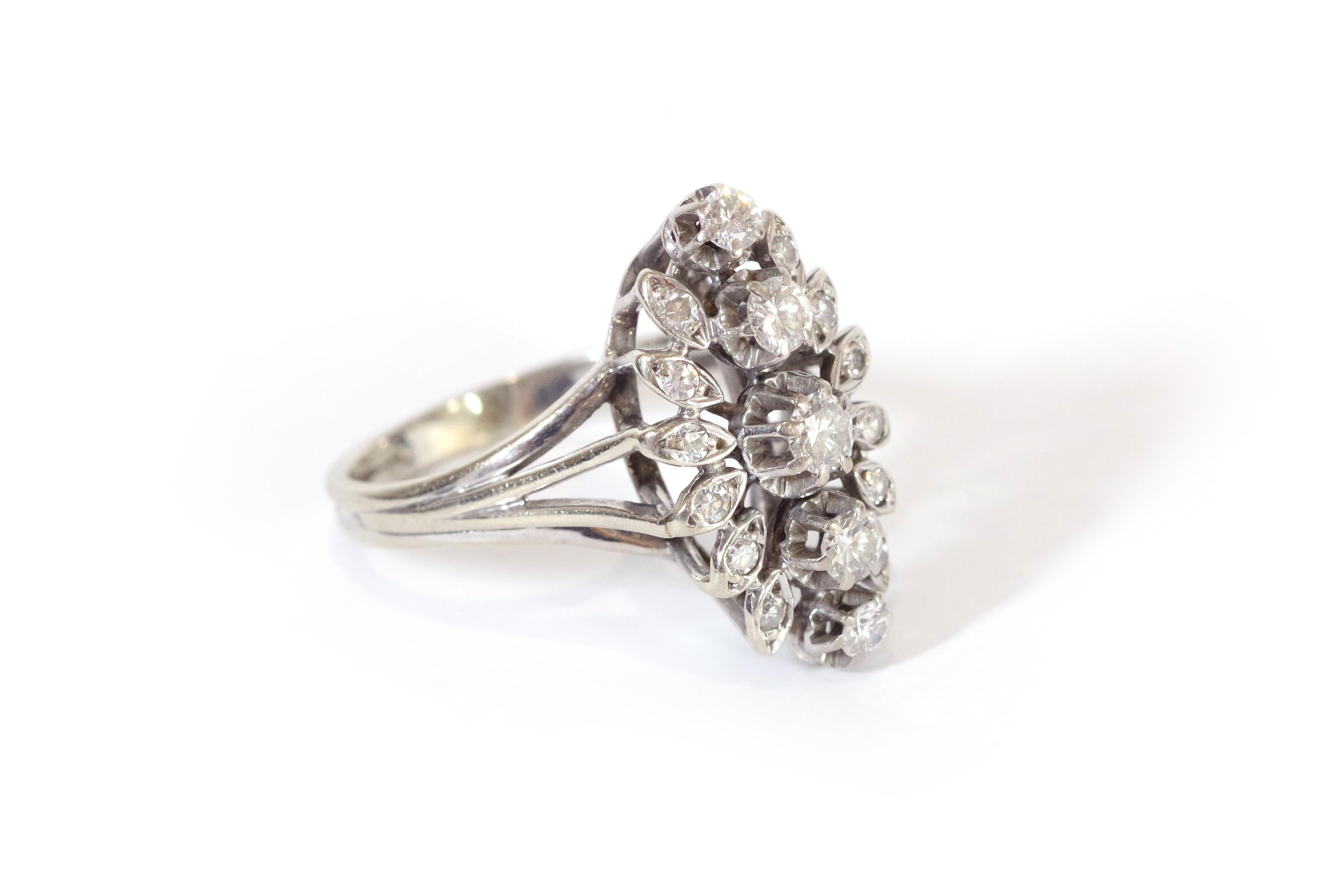 Navette diamond ring in 18 karat white gold. The ring is set with a line of five brilliant-cut diamonds, surrounded by twelve brilliant-cut diamonds, set in a leaf motif. The bezel is quite high. Marquise cluster ring from the 1970s. 

Owl hallmark