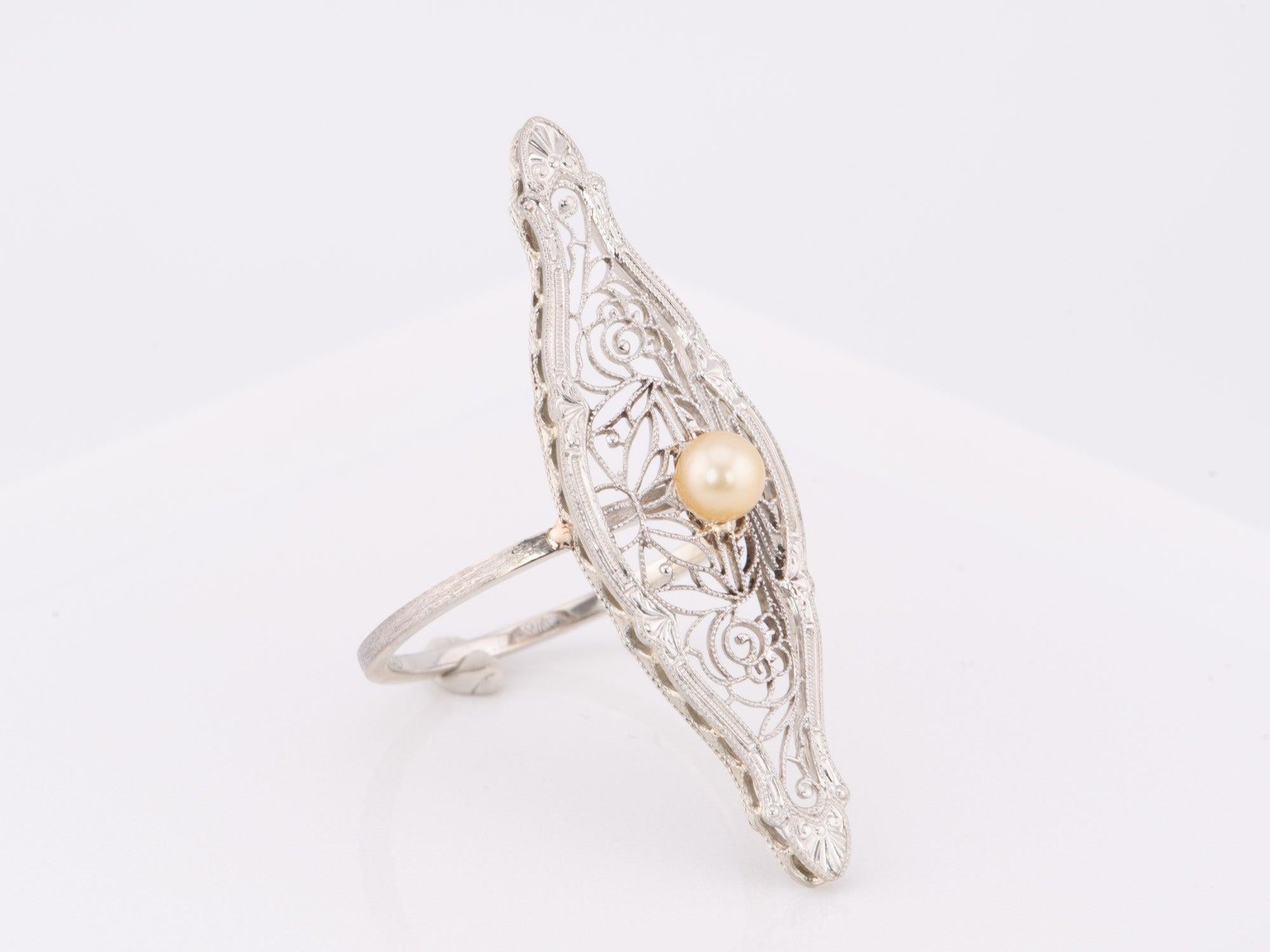   Questo squisito spillone di perle vintage convertito in anello a navette è un pezzo unico realizzato in oro massiccio 14 carati. L'intricato design in filigrana e la lunga forma a marquise adorneranno qualsiasi mano. Un'aggiunta perfetta a