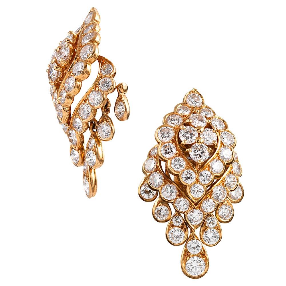Exceptional in their design, these earrings are conceived as a three-dimensional navette-shape, with graduated pear drops suspended from a stationary cluster of diamonds. The teardrop-shapes cascade down the sides, continuing the scalloped border