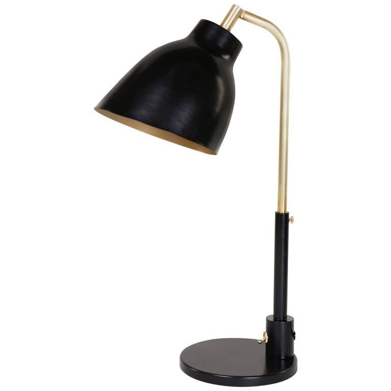 Dimensions: W 7in (18cm) x D 8in (20.5cm) x H 18in (46cm)

The Navire table lamp is part of Atelier de Troupe's classic Navire collection inspired by nautical lamps of the 1930s. The lamp has an adjustable solid brass arm and a tilting shade.