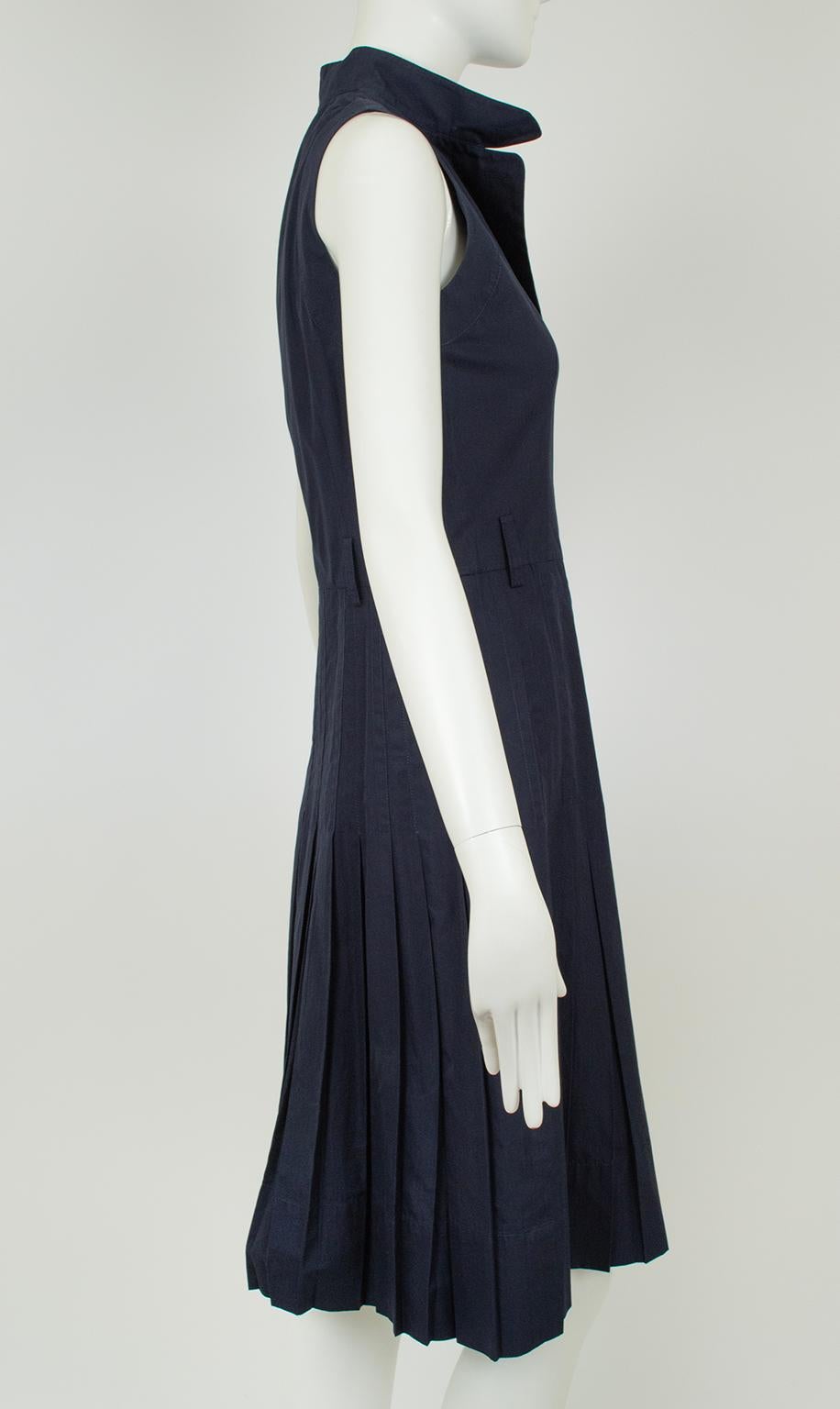 Charmante et BCBG, cette robe de jour est parfaite lorsque le temps appelle un tissu léger mais que l'événement exige un style sur mesure. Un corsage sans manches boutonné sur le devant est équilibré par une jupe à plis couteaux dont les plis sont