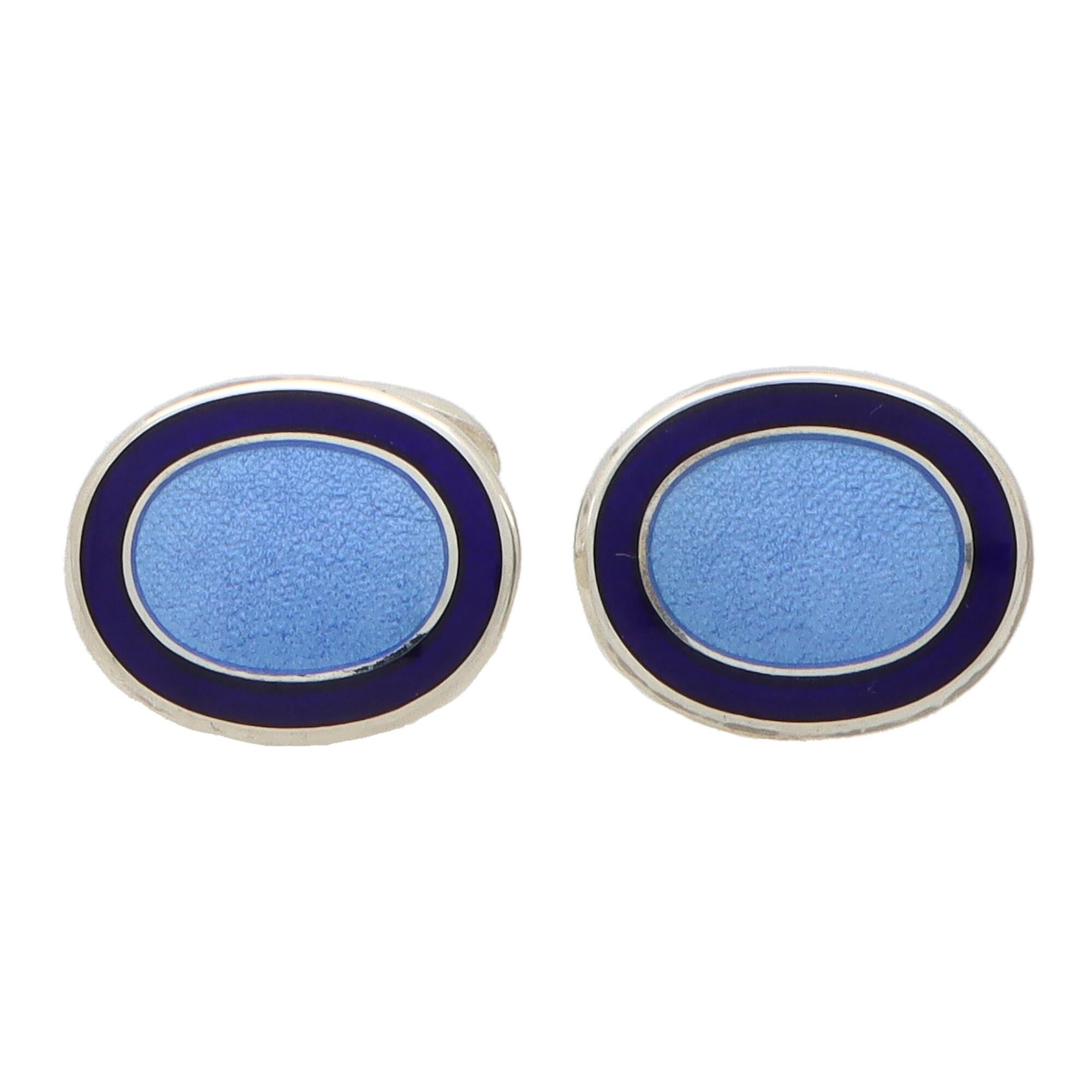 A stylish pair of navy and light blue enamel swivel back cufflinks made in British sterling silver.

Each cufflink is composed of two oval faces set centrally with a textured light blue panel and bordered by navy blue. They are secured to reverse
