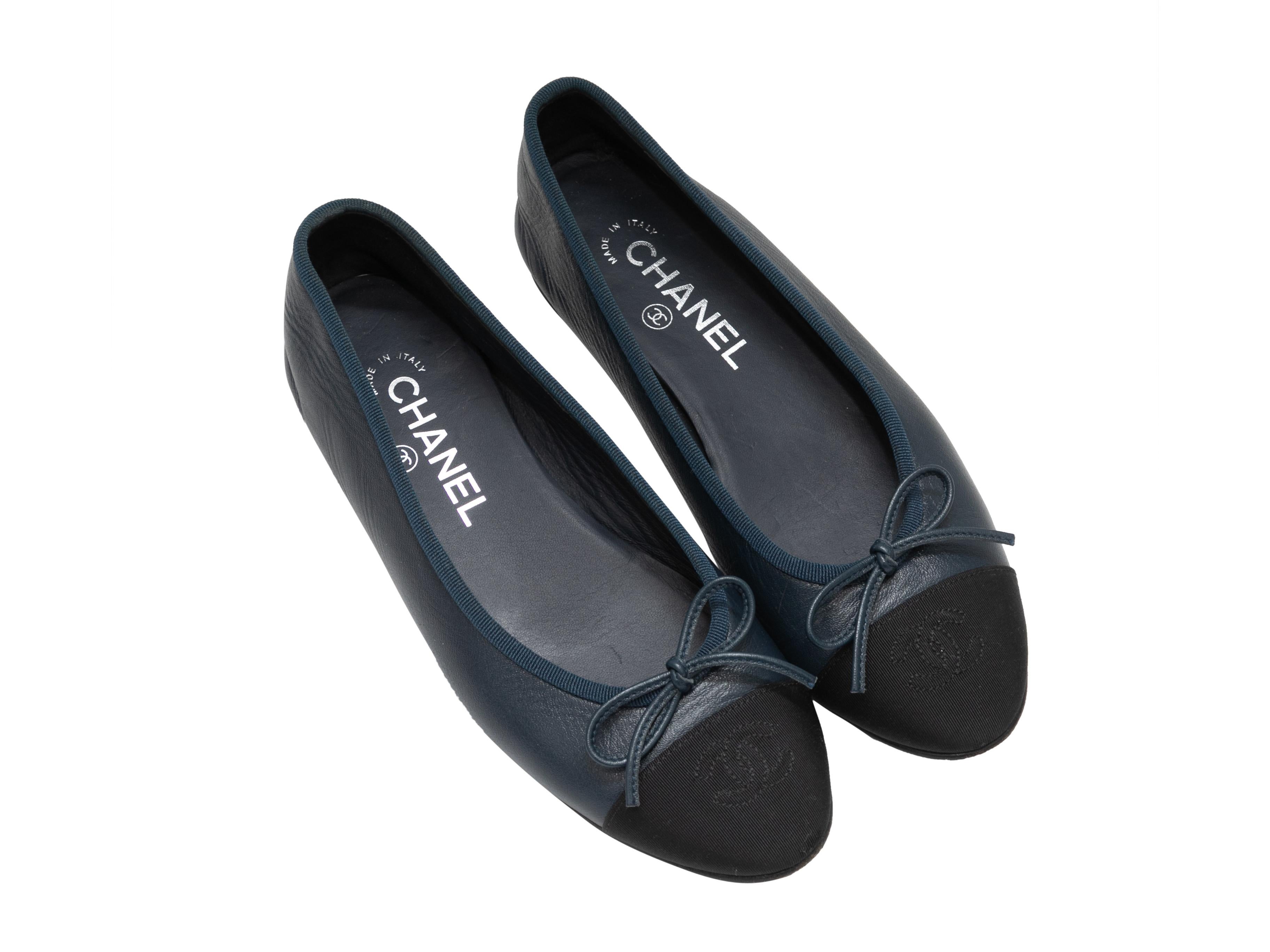 Navy leather and black grosgrain cap-toe ballet flats by Chanel. CC logo embroidery and bow accents at tops.

Designer Size: 36.5
US Recommended Size: 6.5