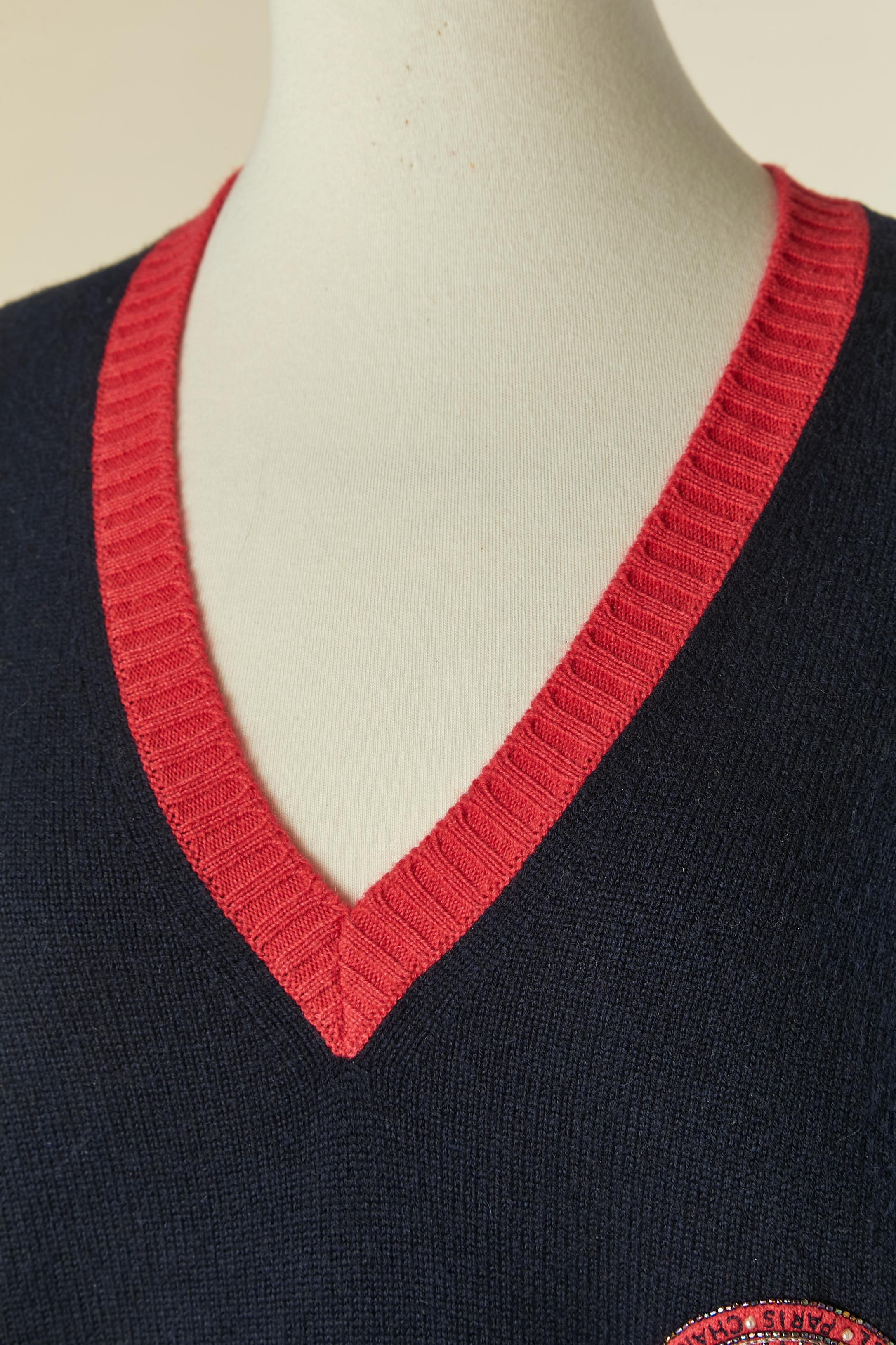 Maglione in cashmere blu navy e rosso con scollo a V e patch di perline.
taglia 46 / XL 