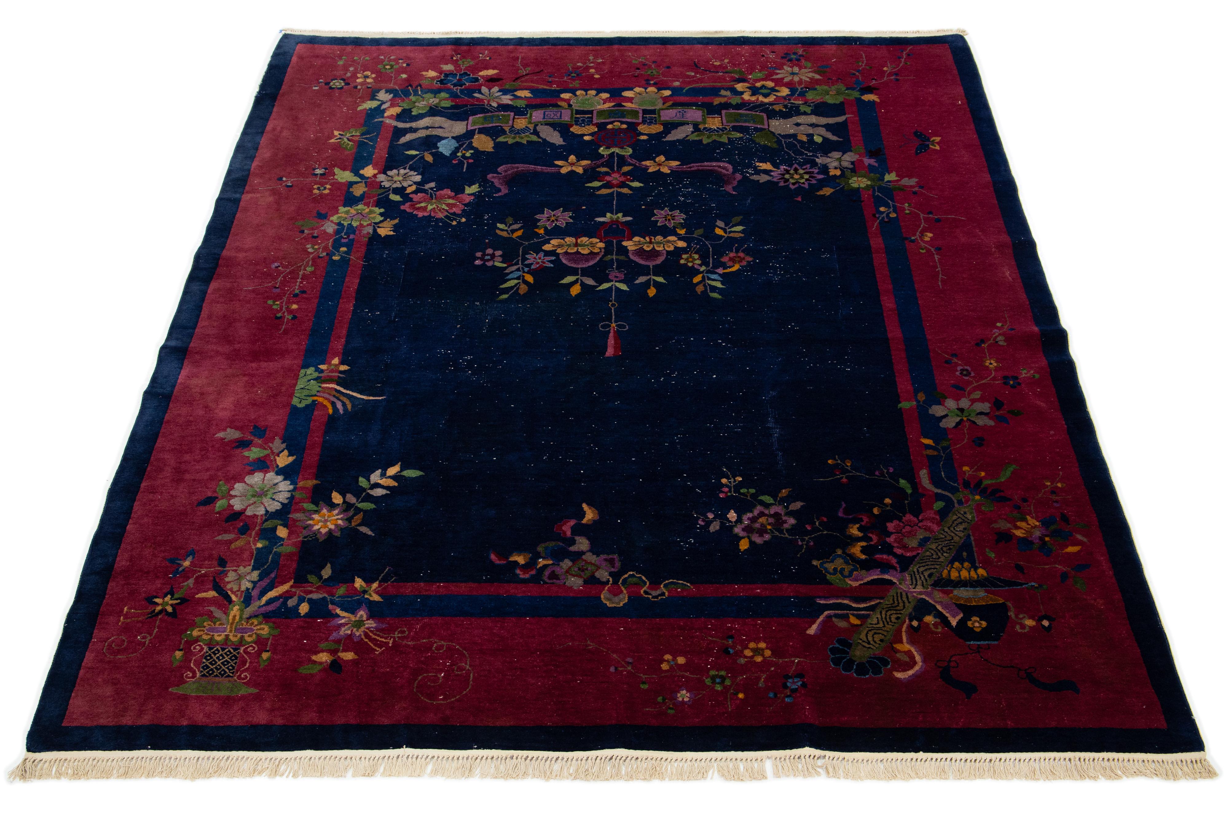 Esta elegante alfombra china antigua de lana Art Decó presenta un campo de color azul marino con un borde decorativo en rojo y acentos vibrantes, mostrando un impresionante motivo chino clásico.

Esta alfombra mide 9' x 11'.

 