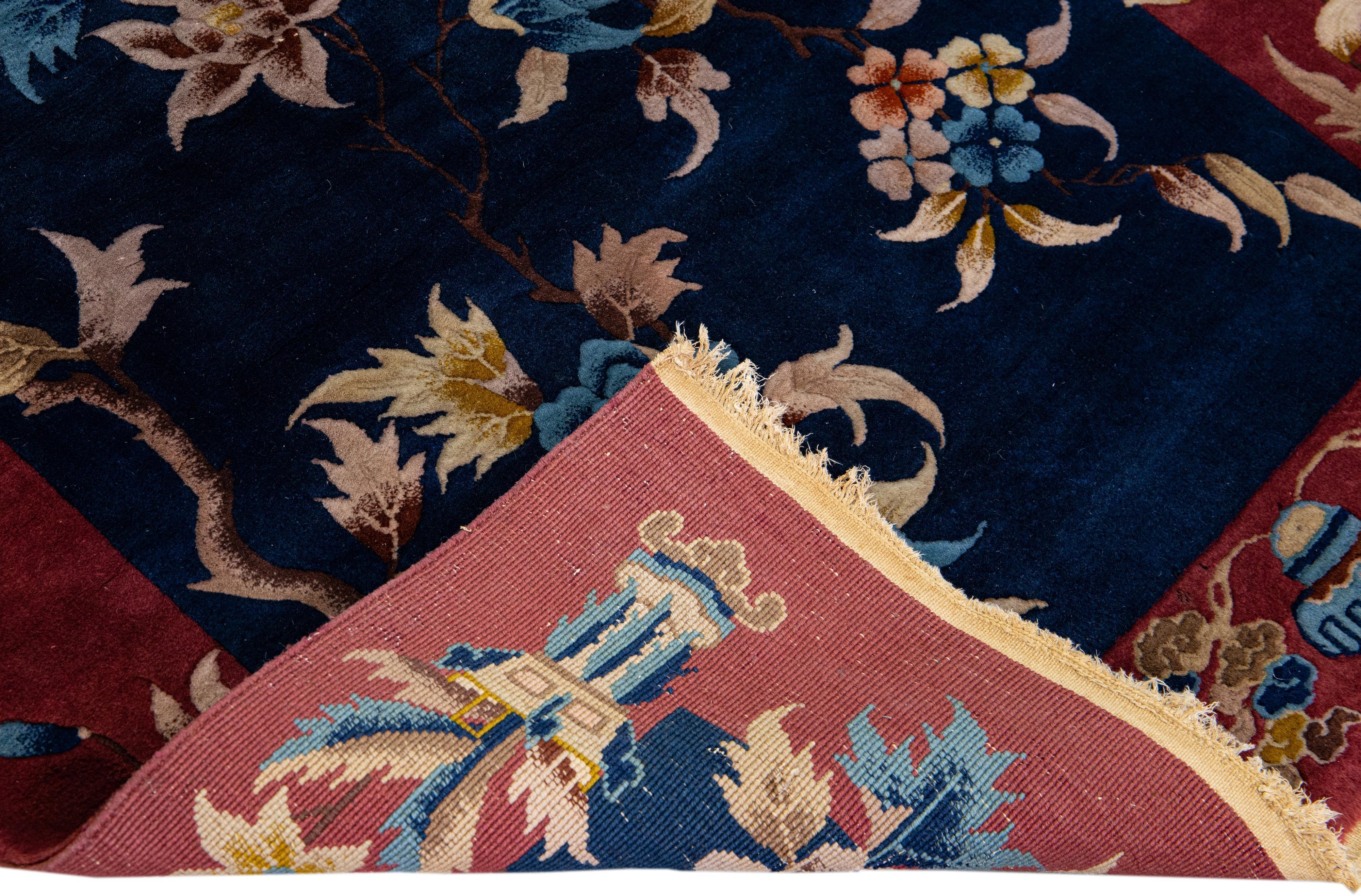 Beautiful antique Art Deco Chinese hand-knotted wool rug with a navy blue field. This Chinese rug has a red frame and multicolor accents layout in a gorgeous Chinese floral design. 

This rug measures: 3'10