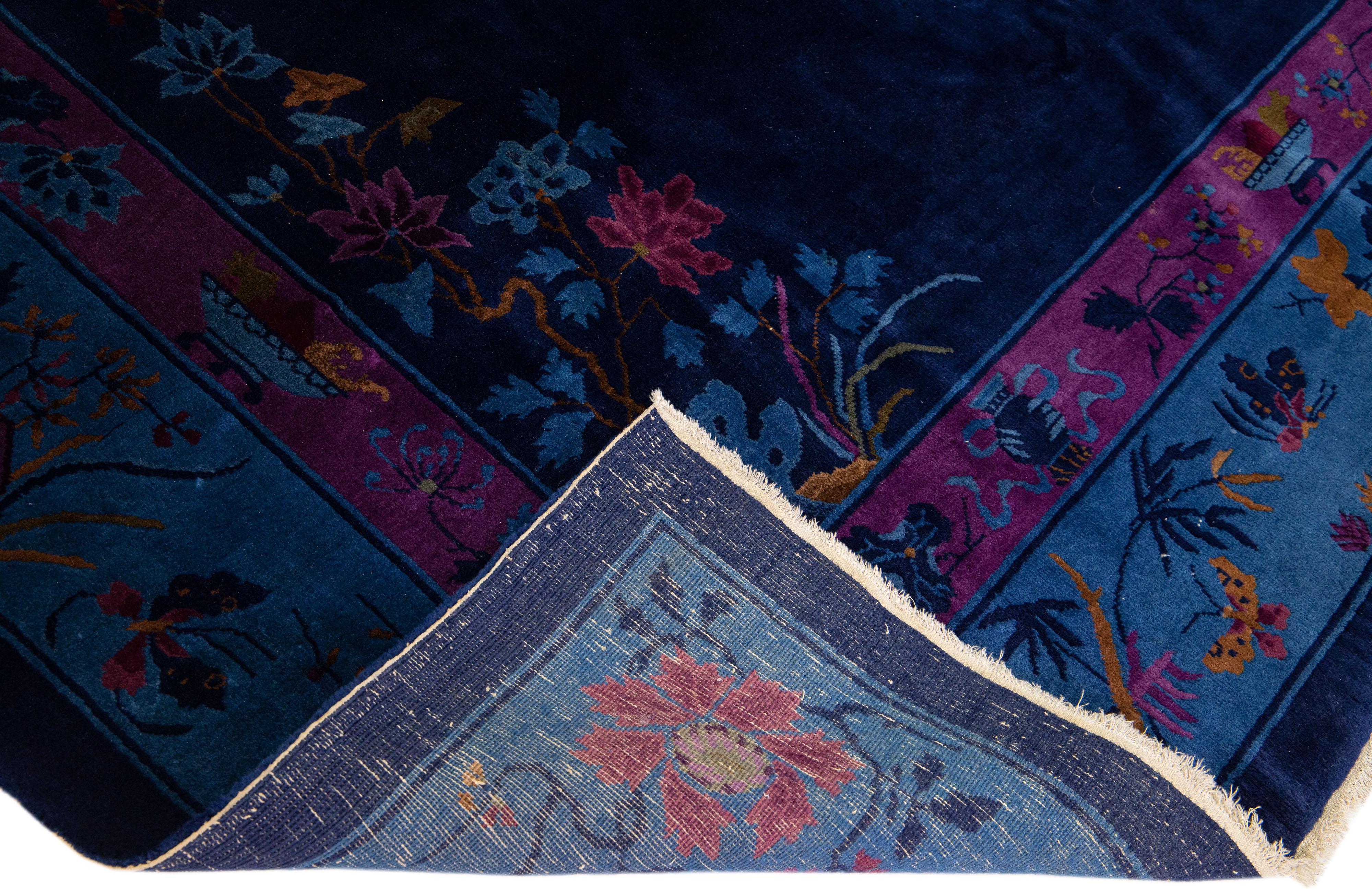 Schöner antiker Art-Deco-Teppich aus handgeknüpfter Wolle mit einem marineblauen Farbfeld. Dieses Stück hat einen violetten Rahmen mit mehrfarbigen Akzenten in einem wunderschönen traditionellen chinesischen Blumendesign. 

Dieser Teppich misst: