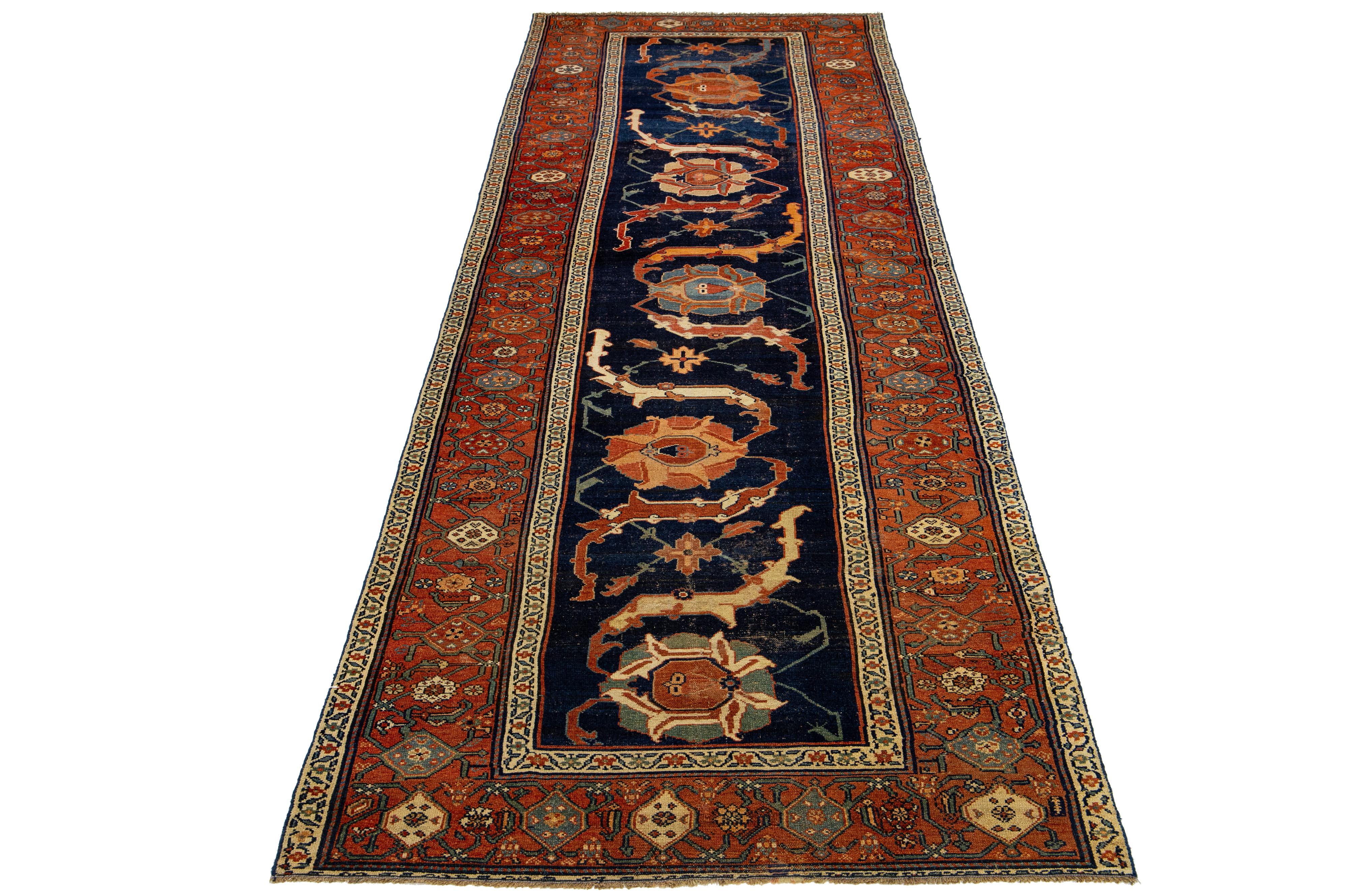 This Persian Malayer wool rug exudes an antique charm. It showcases hand-knotted wool in a navy blue field with an allover pattern embellished with accents of rust, beige, and orange.

This rug measures 4'6