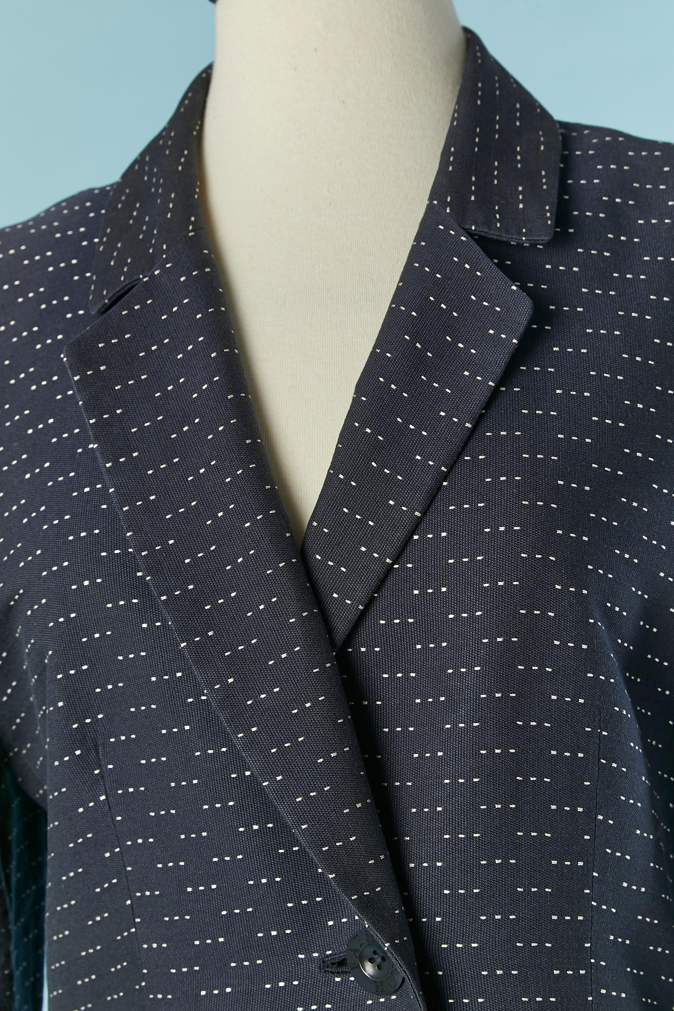 Navy blue cotton skirt-suit with white stitches. Main fabric composition: 96% cotton, 4% silk. Acetate lining. 
Shoulder pad. Pockets on both side. Branded button and buttonhole closure on the middle front. 
SIZE 14 (US) but fit L 