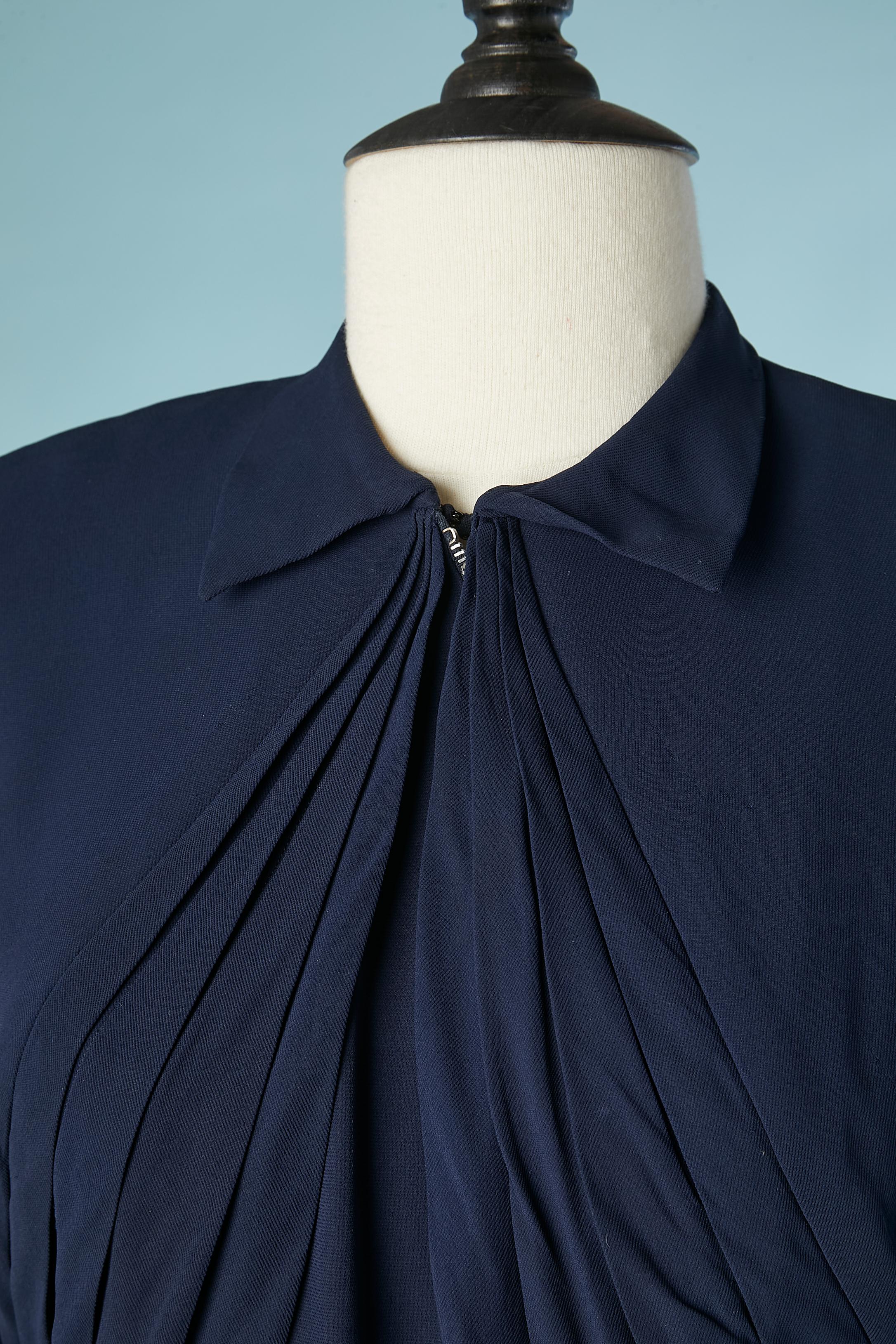 Navy blue crepe cocktail dress pleated on the bust . Asymmetrical zip underneath going from the middle  top until the left side of the waist. Hook&eye on the waist. Shoulder-pads. Raglan sleeves. Pocket on both side. Extra lay of pleated fabric on