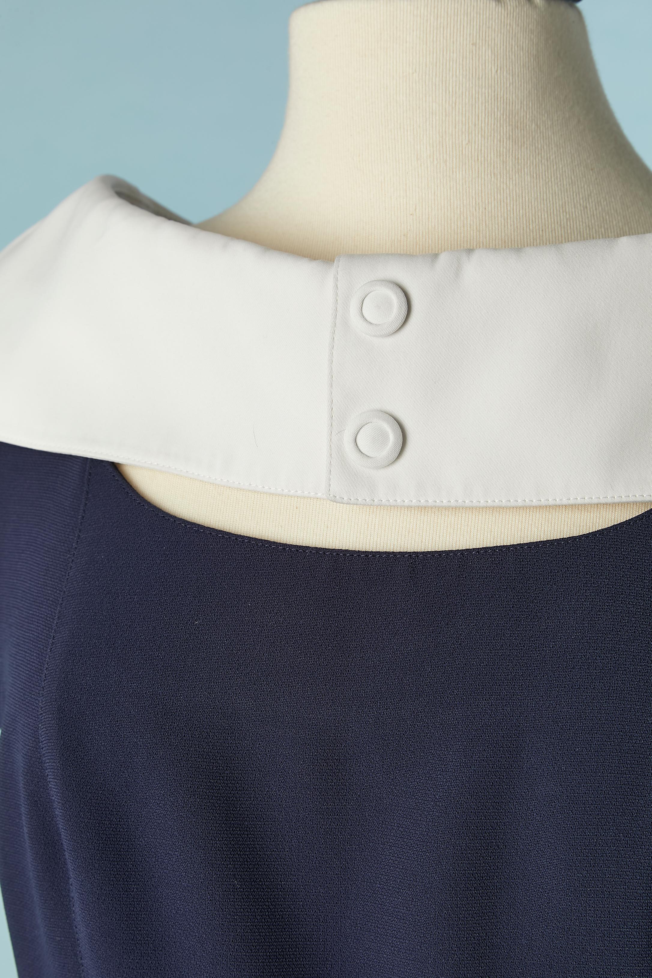 Navy blue dress with white collar and edge. No fabric composition but the navy blue fabric could be crêpe. The white collar and bottom edge is cotton. Lining is probably acetate. Snap covered with cotton on the detachable ( with snaps) collar. Zip