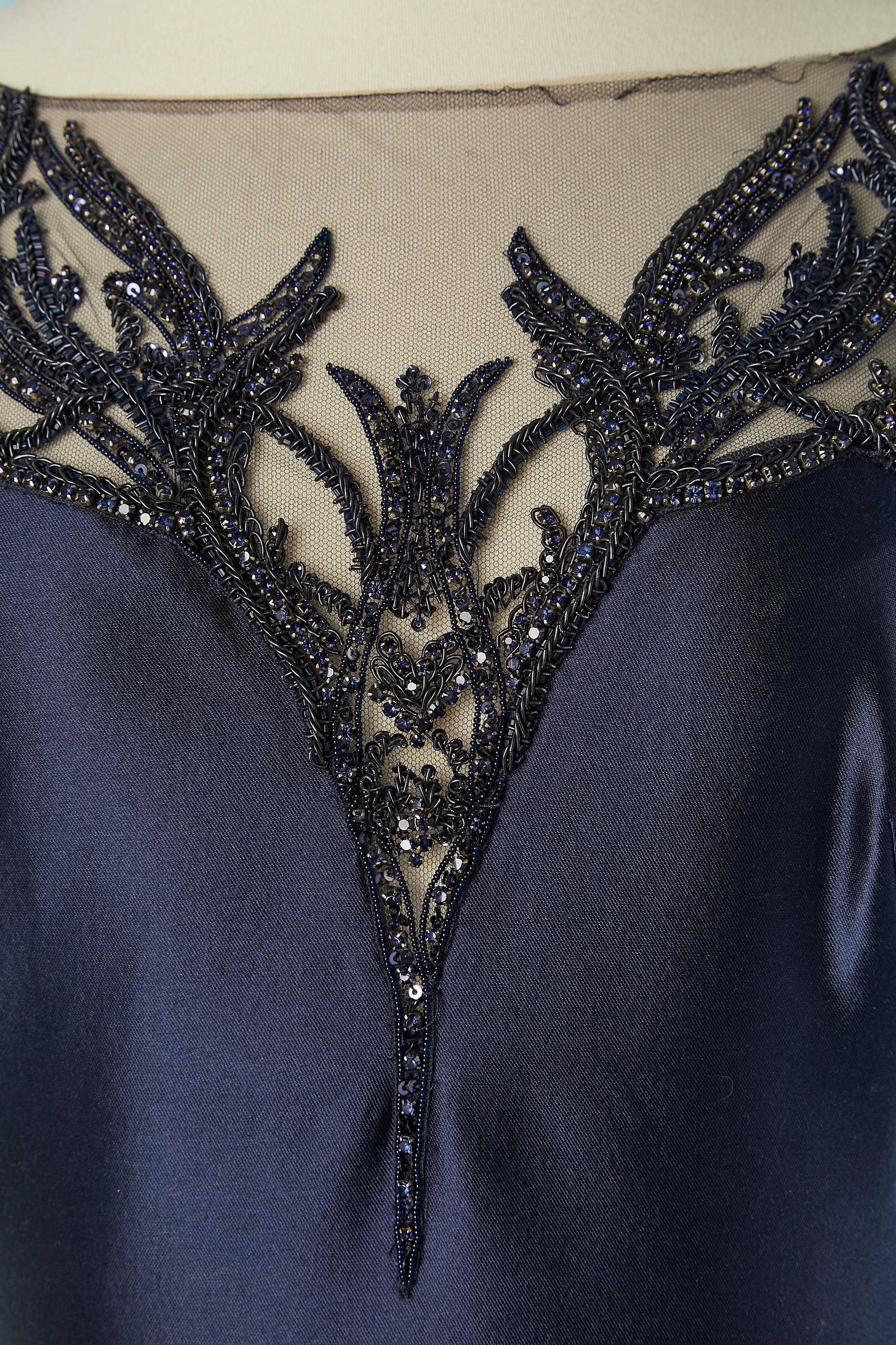 Navy blue evening gown in twill silk and embroideries ( black rhinestone, beads and thread) with drag and flare bottom. 
Silk lining. Stiff tulle petticoat with ruffles under the flare part with stiff organza  lining. Zip closure and hook&eye on the