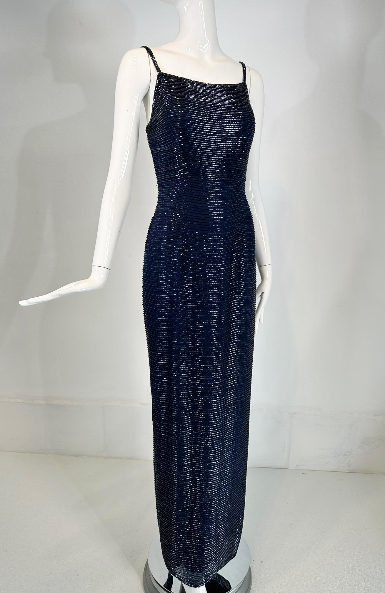 Saks 5th Ave navy blue glass beaded silk evening dress. Slip style maxi dress with beaded spaghetti straps, an open neckline at the front  back. The dress is fitted through the torso and tapers to the hem, there is a deep center hem vent at the