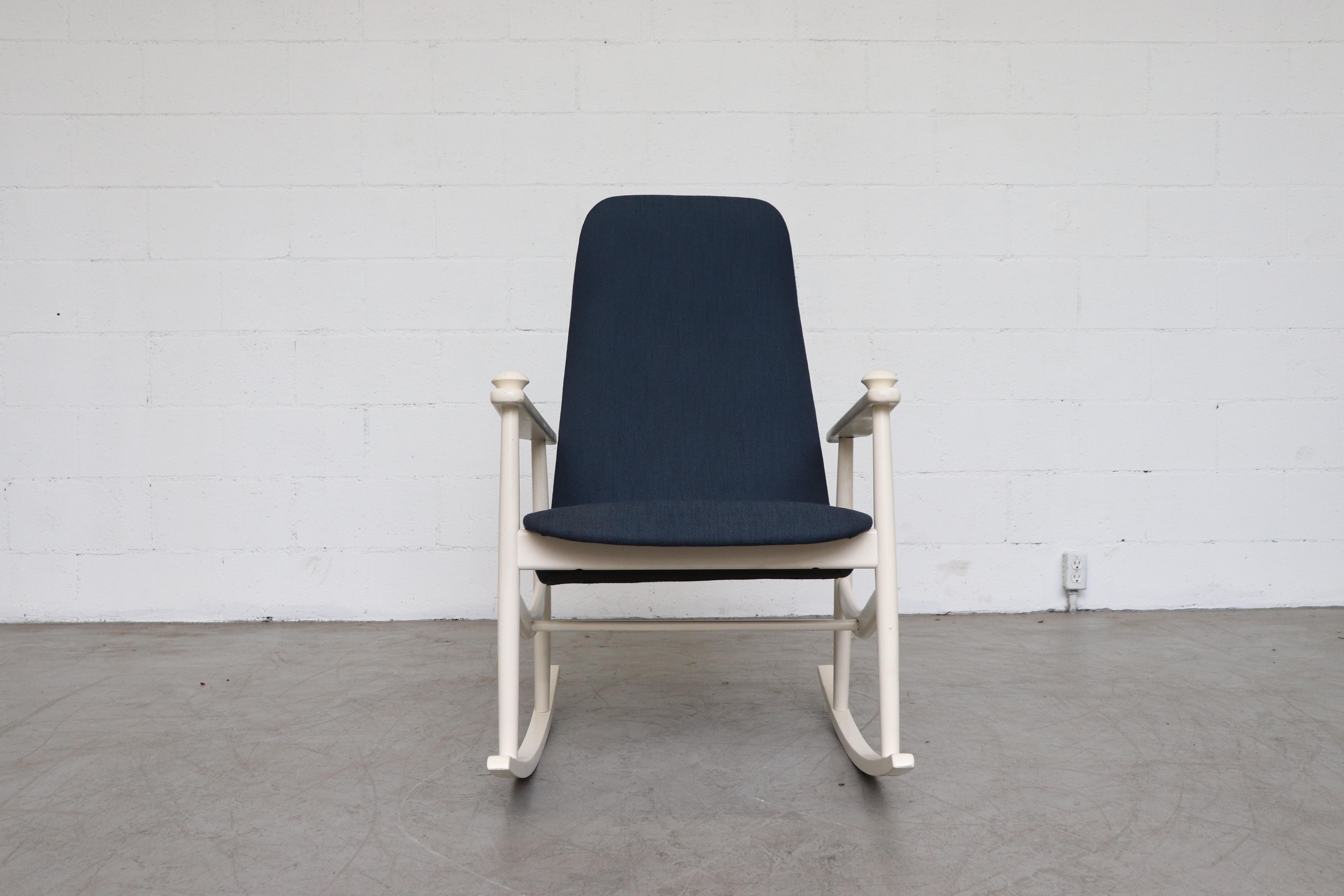 Navy blue high back rocking chair. Newly upholstered. White painted wood frame. In good original condition with some signs of visual wear consistent with age and use. Details in photos.