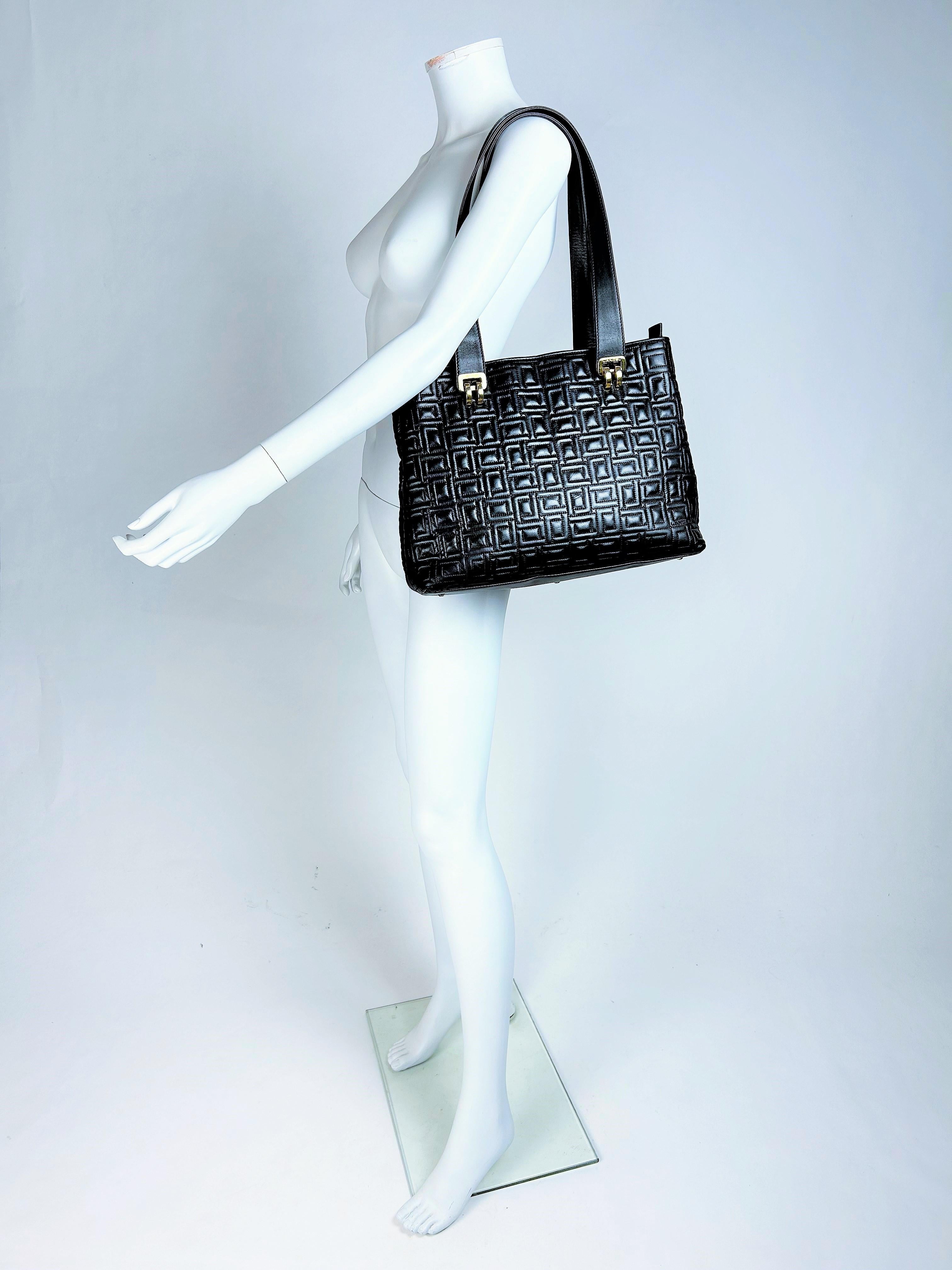 Alrededor de 1990
Francia
Elegante bolso grande de piel azul marino con pespuntes de cuadros de la famosa marca Lancel, de la década de 1990. Forma de besace con dos compartimentos interiores cerrados por botón a presión y cremallera. Dos asas para