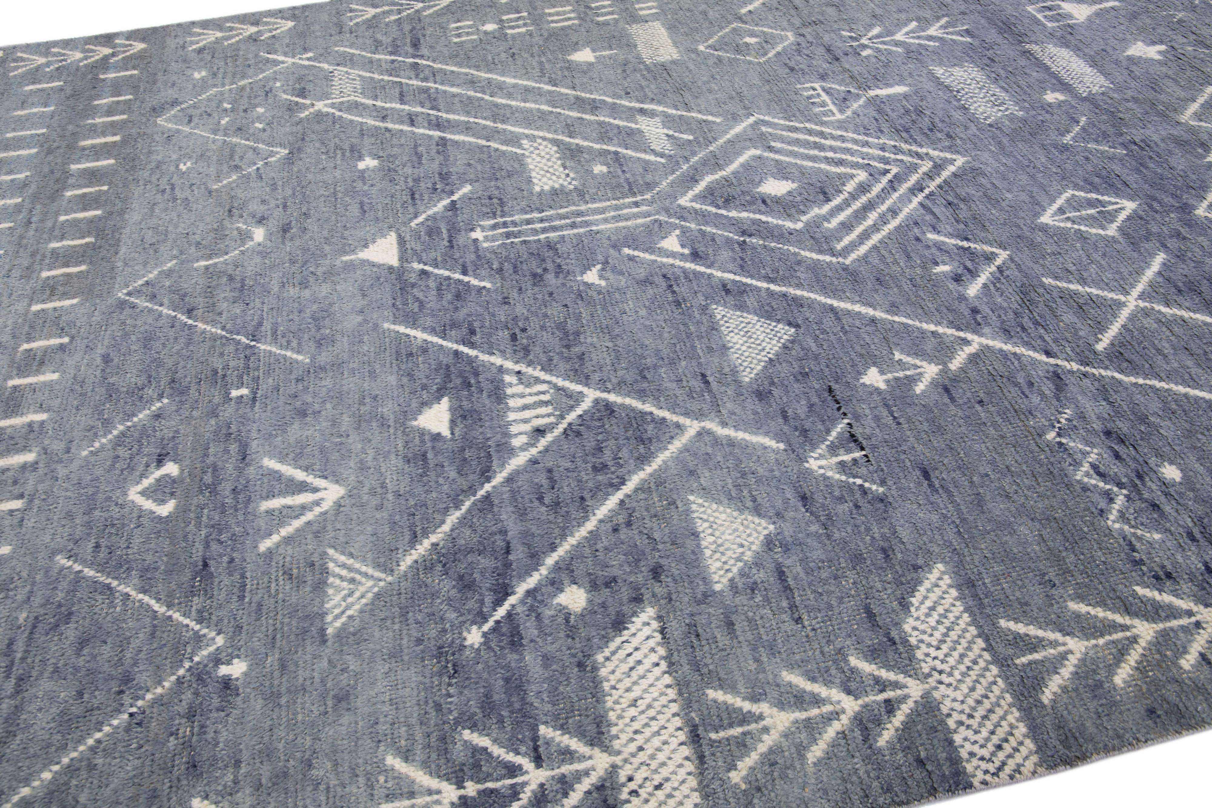 Beautiful moroccan berber style hand-knotted wool rug with a navy blue field. This piece has beige accents in an all-over geometric art deco design.

This rug measures: 9' x 12'1