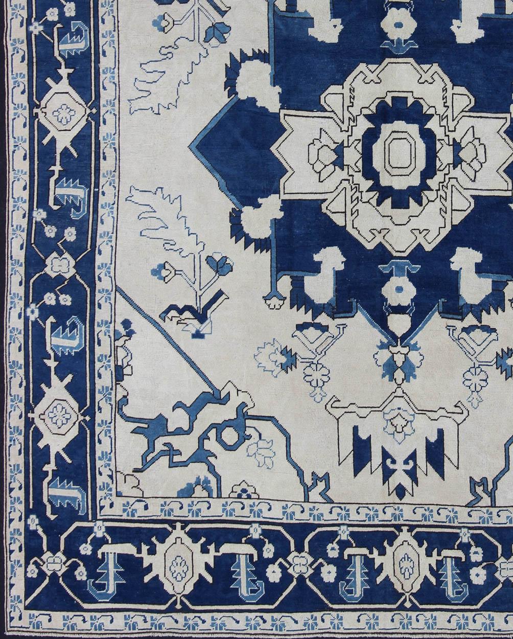 Vintage Oushak with Botanical Medallion design in blue and ivory, rug en-165935, country of origin / type: Turkey / Oushak, circa 1940

This vintage Oushak carpet from mid-20th century Turkey features a traditional medallion design rendered in