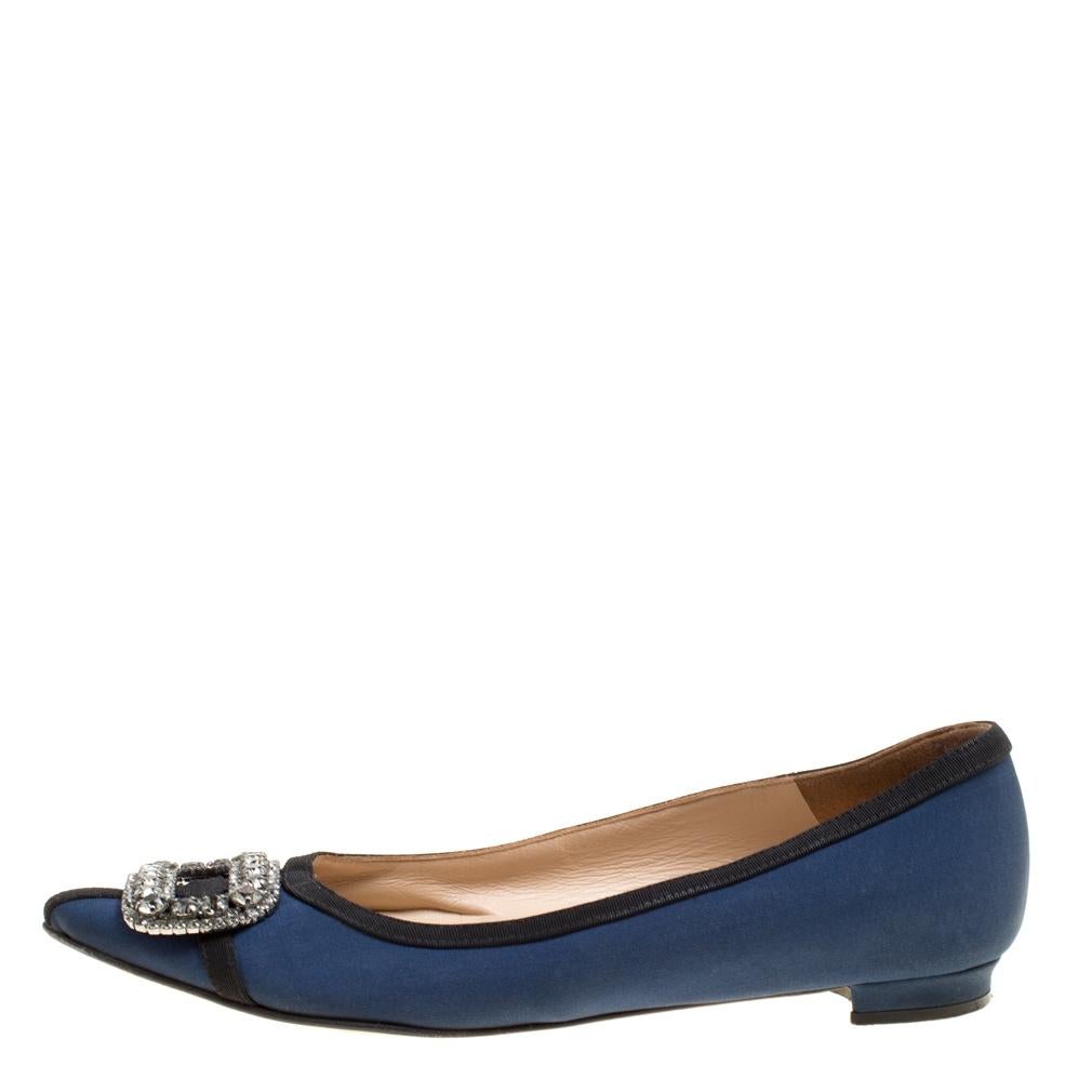 A classic pair of Manolo Blahniks is loved by women all over for its comfort and grace. These pretty shoes are constructed from navy blue satin fabric and it further made special with a buckle style crystal embellished design at the front which is