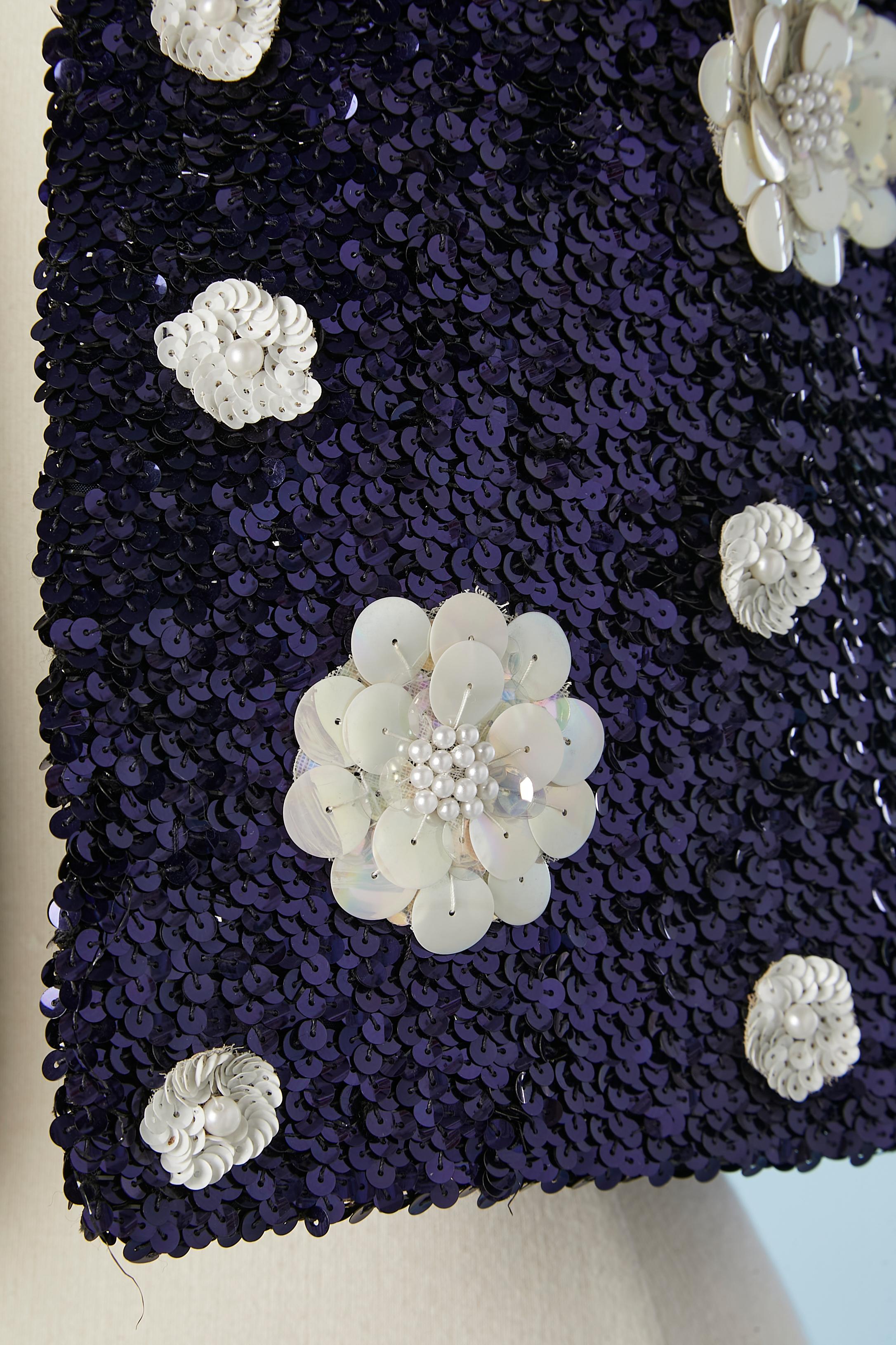 Boléro bord à bord en paillettes bleu marine avec fleurs en paillettes et perles blanches. Pas de composition d'étiquette de tissu mais la doublure est probablement de la rayonne ou de l'acétate. 
TAILLE M 