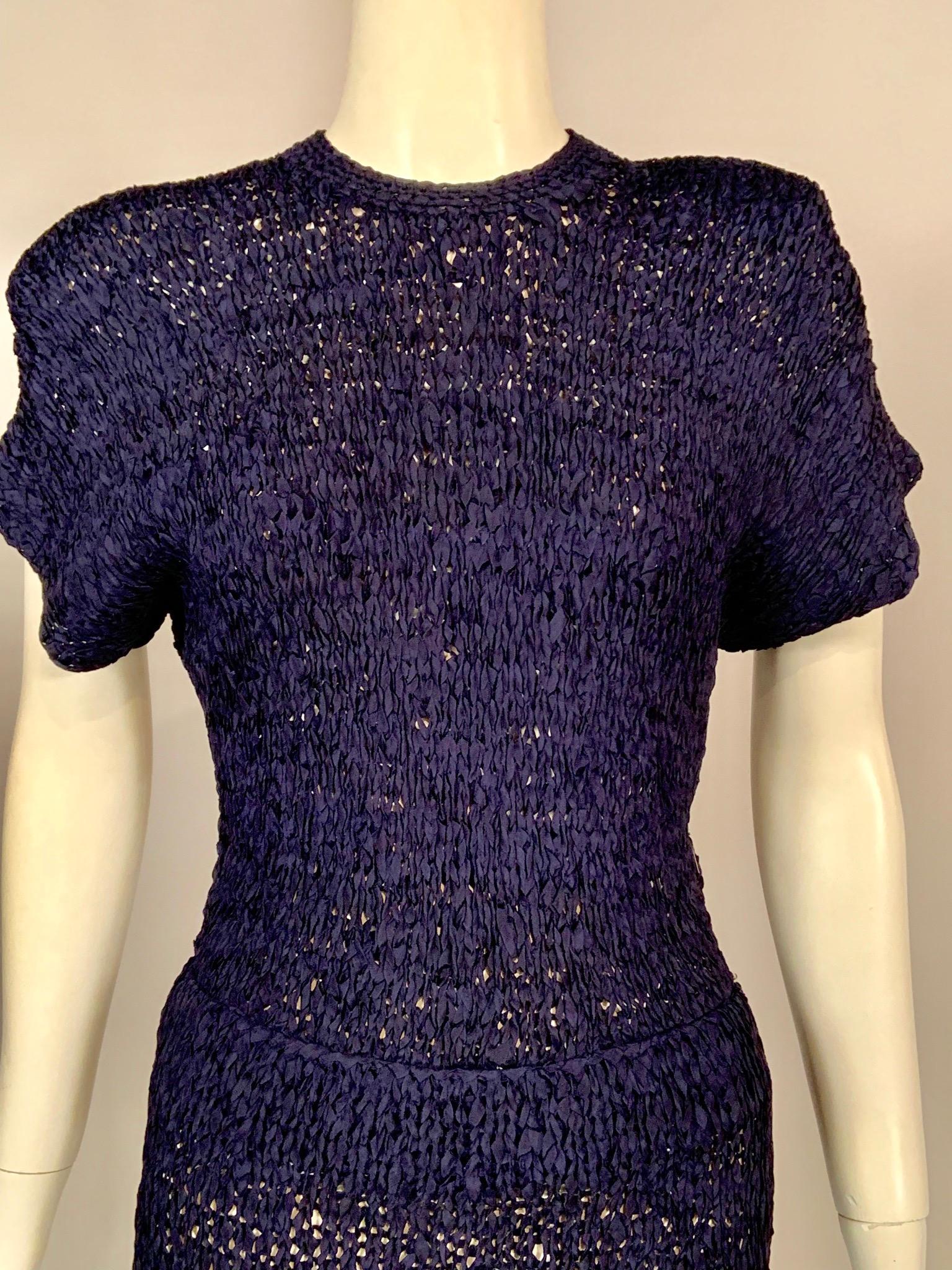 This hand made navy blue silk ribbon dress is in absolutely perfect condition. The dress has a
sexy figure hugging fit which is very flattering.
It has a round neckline, cap sleeves with small shoulder pads, a short center back zipper as well as a