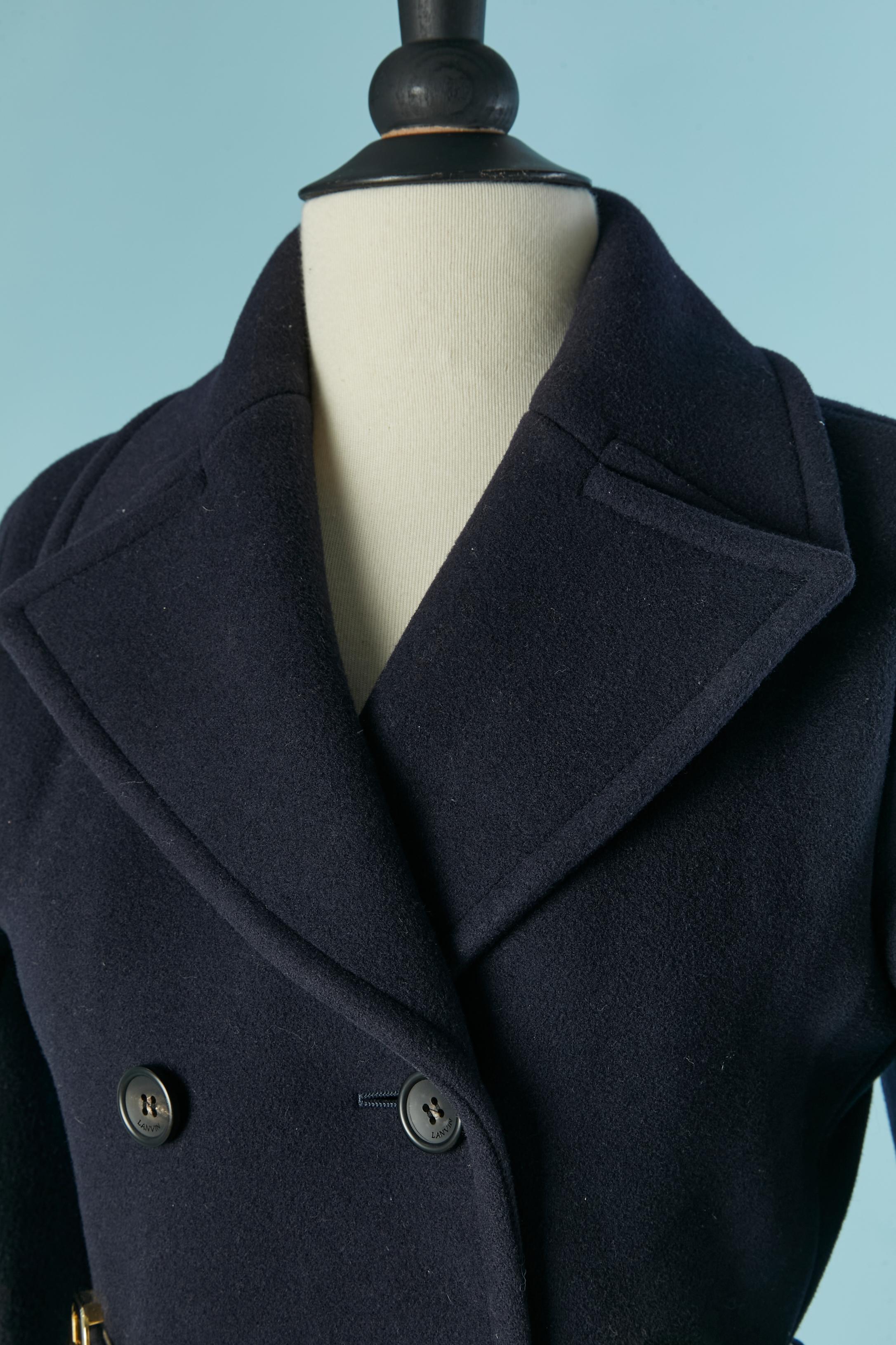 Cappotto monopetto blu navy e lana  cintura con fodera in pelle bianca. Fodera in rayon e cupro e fodera in rayon a righe all'interno della manica.
Chiusura con bottone e asola con marchio sul davanti. Tasca su entrambi i lati. Manica raglan.