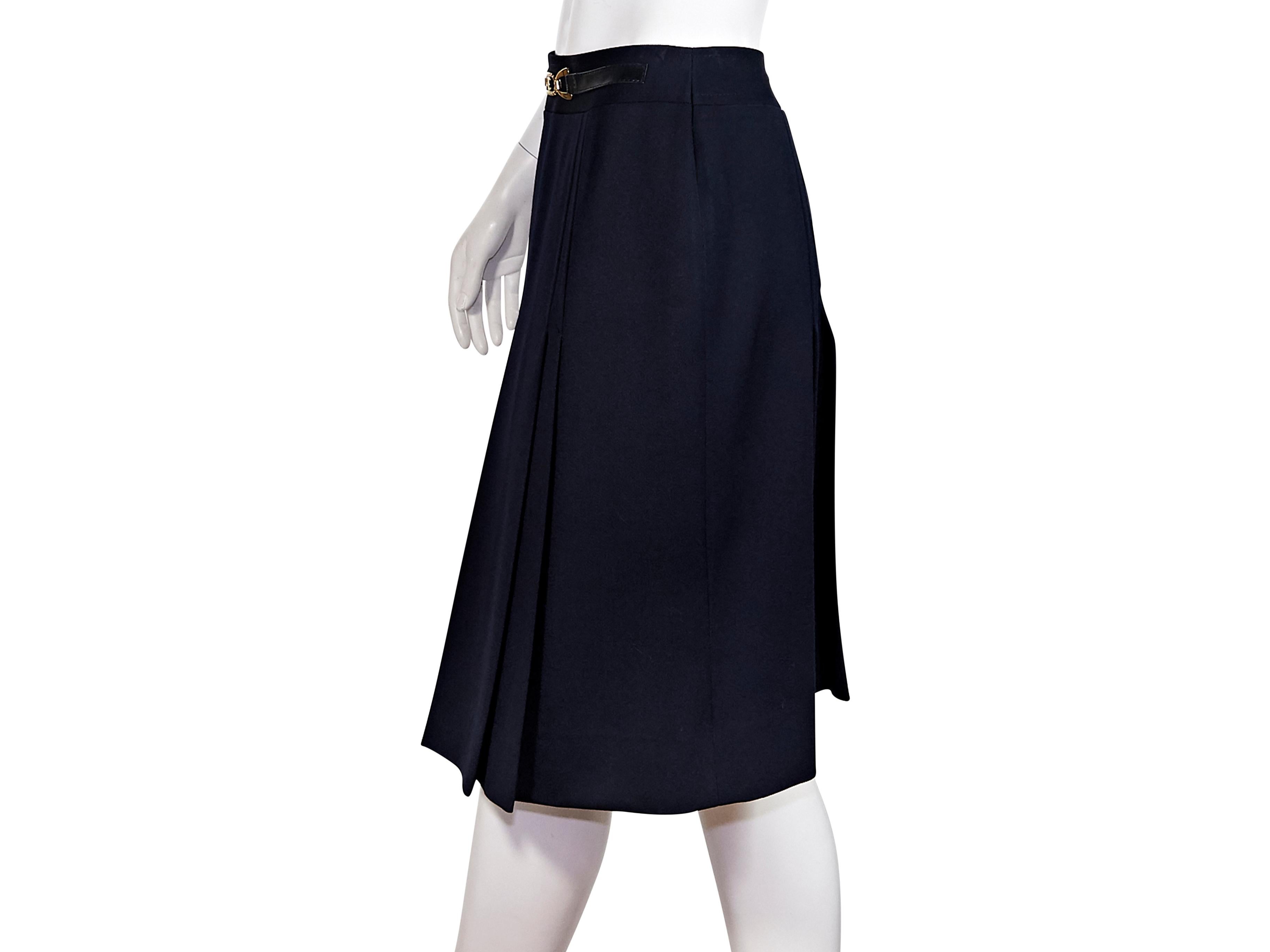 Product details:  Vintage navy blue wool pleated skirt by Celine.  Circa the 1980s.  Banded waist with faux belted front.  Concealed back zip closure.  Goldtone hardware.  28