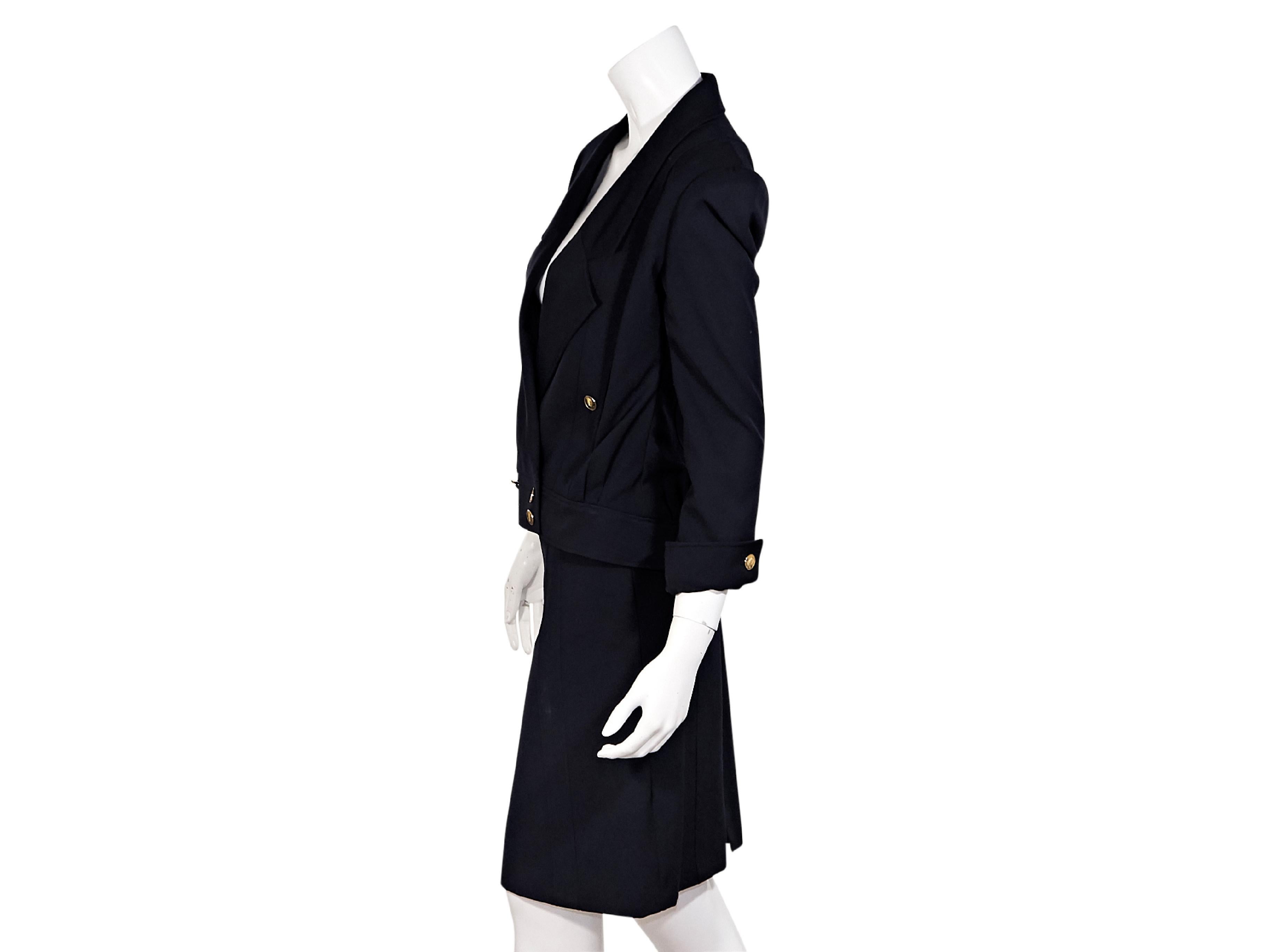 Product details:  Vintage navy blue wool skirt suit set y Chanel.  Circa the 1980s.  Notched lapel.  Three-quarter length sleeves.  Single button cuffs.  Double-breasted button front.  Waist button pockets.  Matching pencil skirt.  Banded waist. 