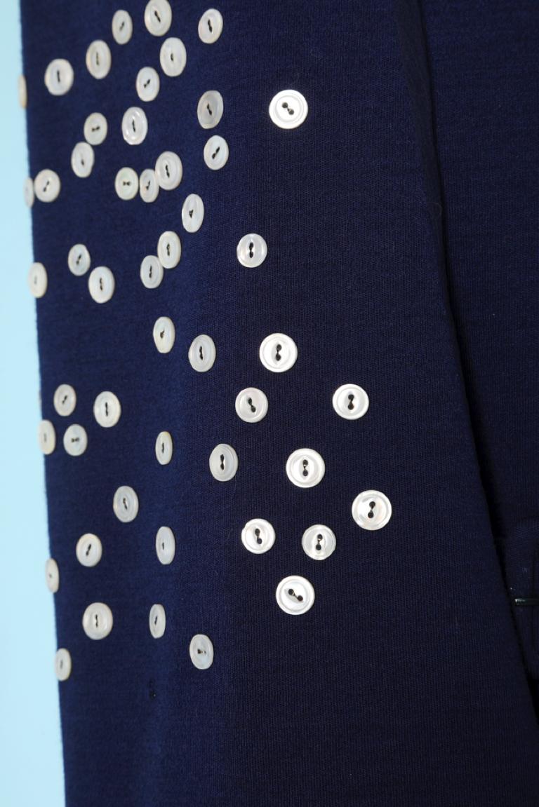 Robe en jersey de laine bleu marine avec col écharpe amovible et boutons en nacre. 
Ceinture et poches. Doublure en soie
TAILLE 10 (US)