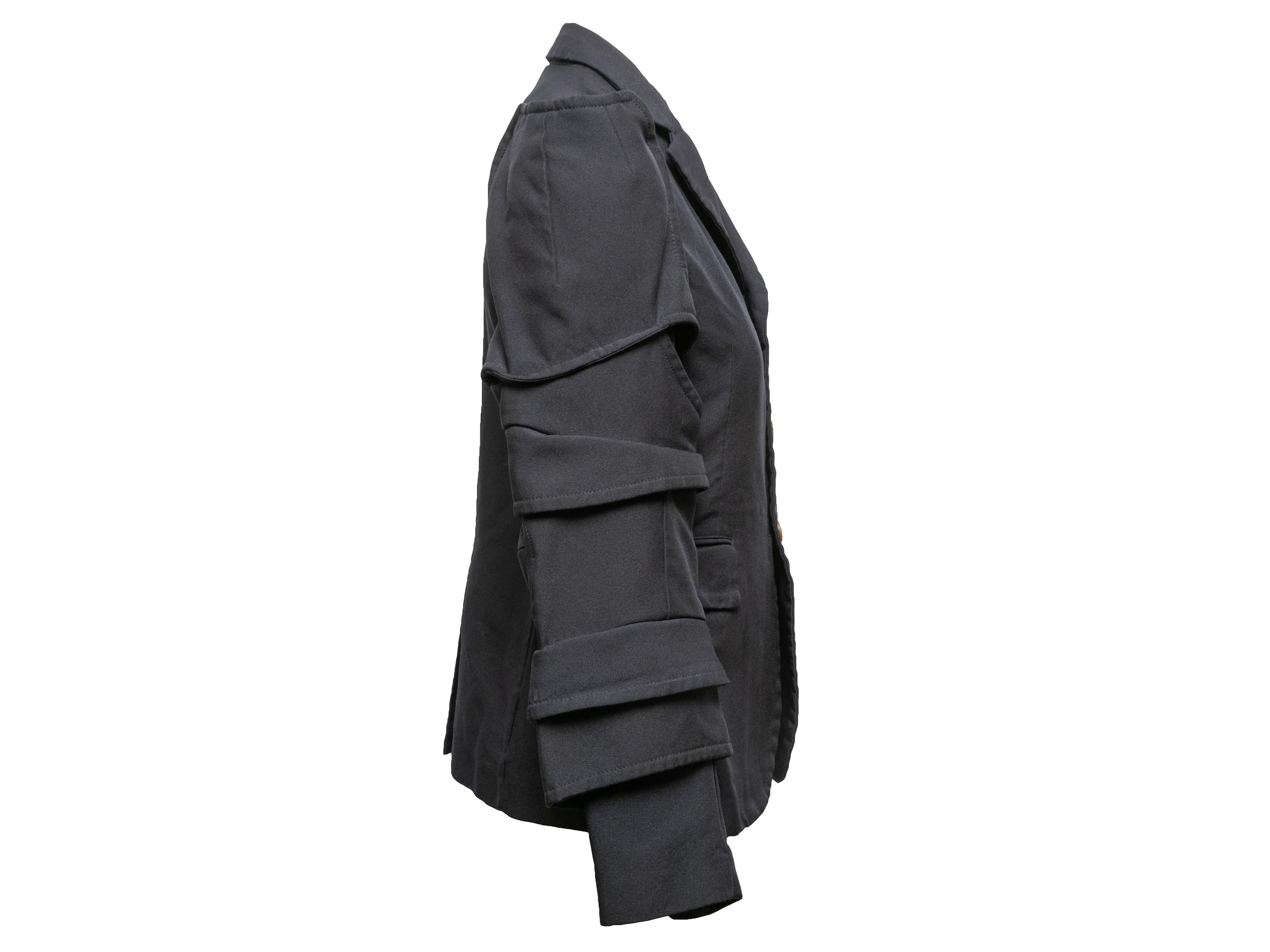 Blazer con bottoni blu scuro di Comme Des Garcons. Risvolto dentellato. Maniche lunghe a strati. Tasca singola sul busto. Doppie tasche sui fianchi. Chiusura con bottoni sul davanti. Seno 32